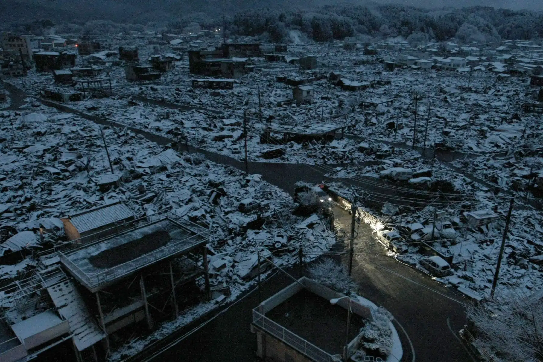 Los faros de los vehículos iluminan el área de desastre de la ciudad de Yamada en la prefectura de Iwate el 16 de marzo de 2011. Foto: AFP