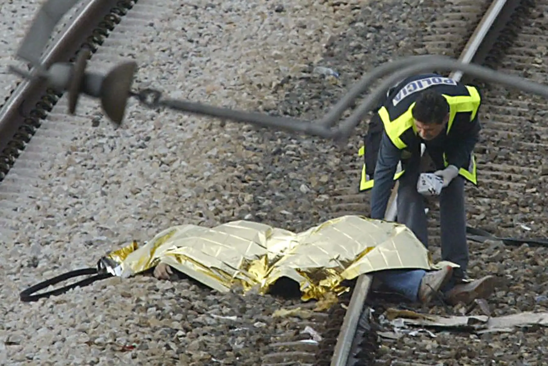 Una mujer policía española examina el cuerpo de una víctima de la explosión de un tren en la estación de tren de Santa Eugenia en Madrid el 11 de marzo de 2004. Foto: AFP