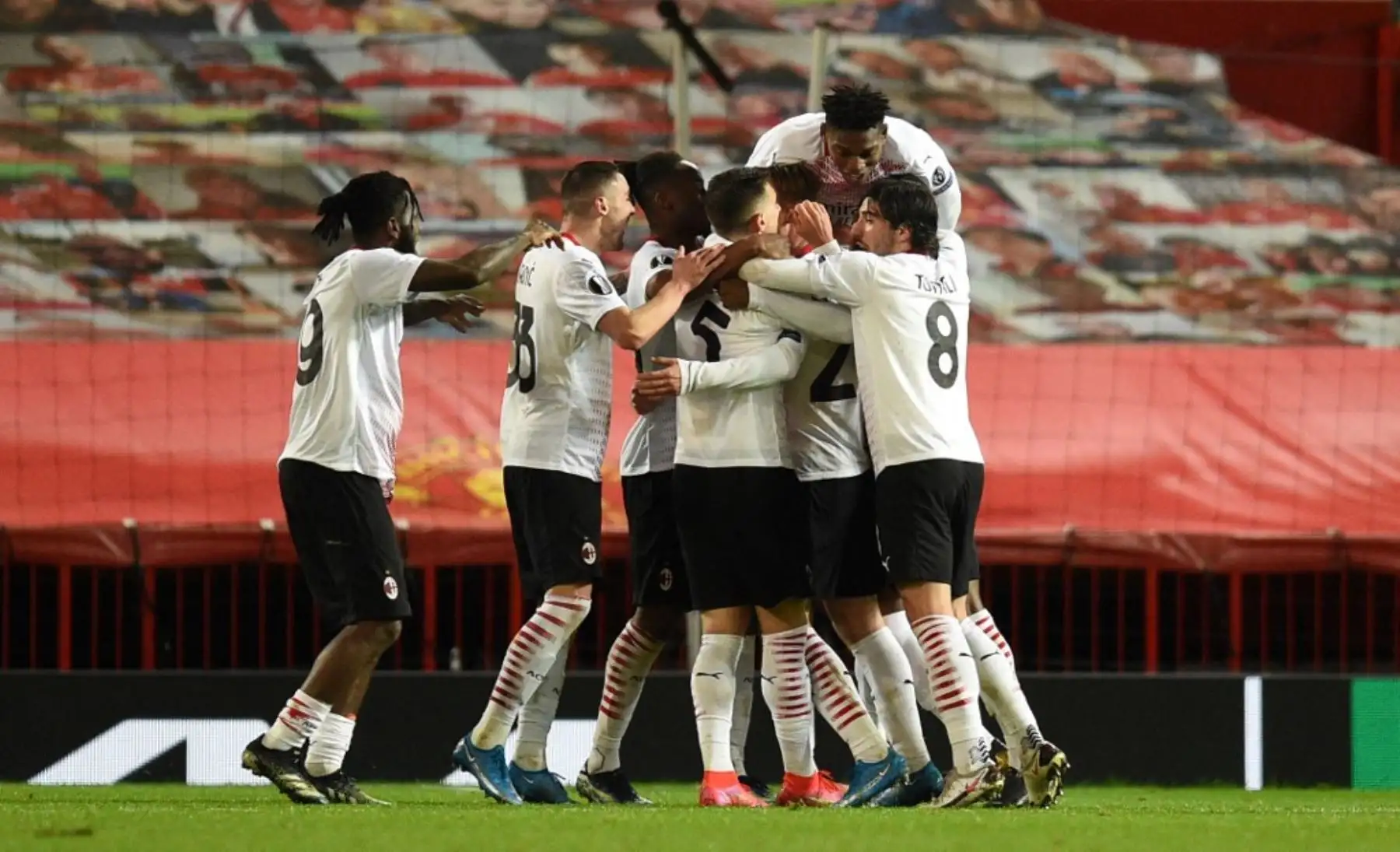 Los jugadores del AC Milan celebran su gol del empate tardío, para hacer el marcador 1-1, durante el partido de ida de los octavos de final de la UEFA Europa League entre el Manchester United y el AC Milan en Old Trafford en Manchester, noroeste de Inglaterra. Foto: AFP