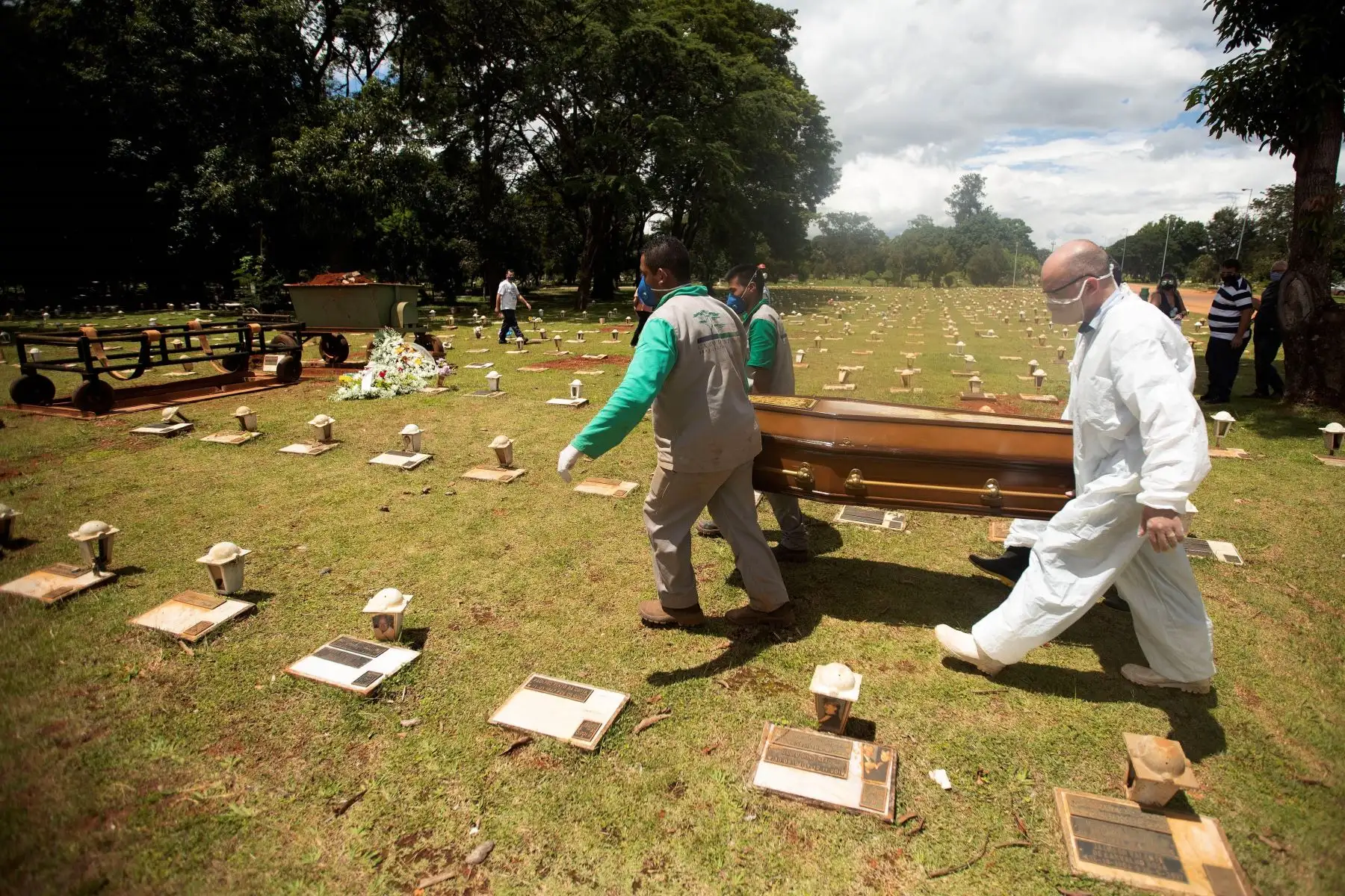 Trabajadores cargan un féretro con una víctima mortal de Covid-19 rumbo a su entierro en el cementerio Campo da Esperança, en Brasilia.
 Foto: EFE