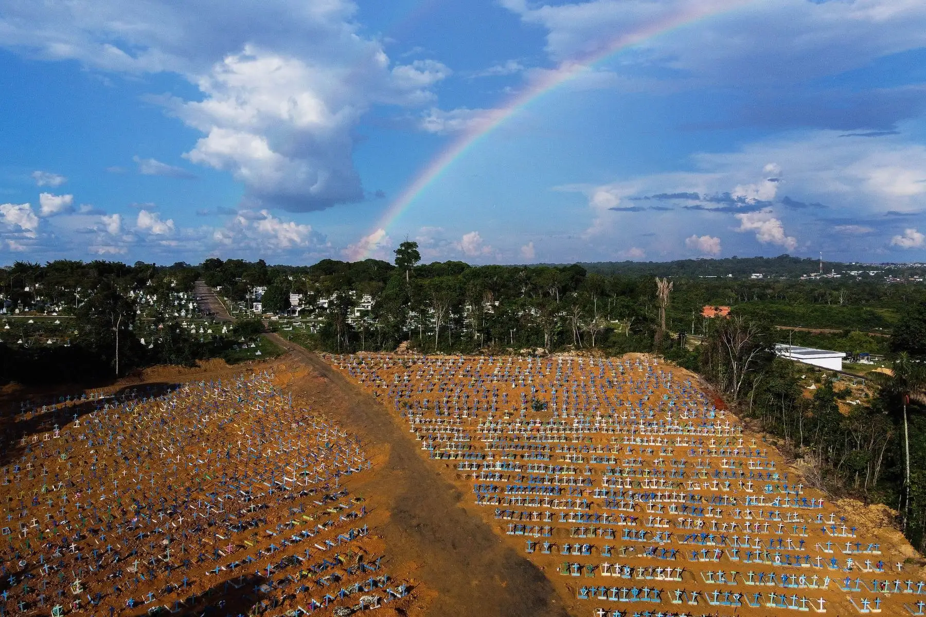 Cementerio reservado para las víctimas de la pandemia COVID con un arco iris en el cielo en el cementerio de Nossa Senhora Aparecida en Manaus, en la selva amazónica de Brasil. 
Foto: AFP
