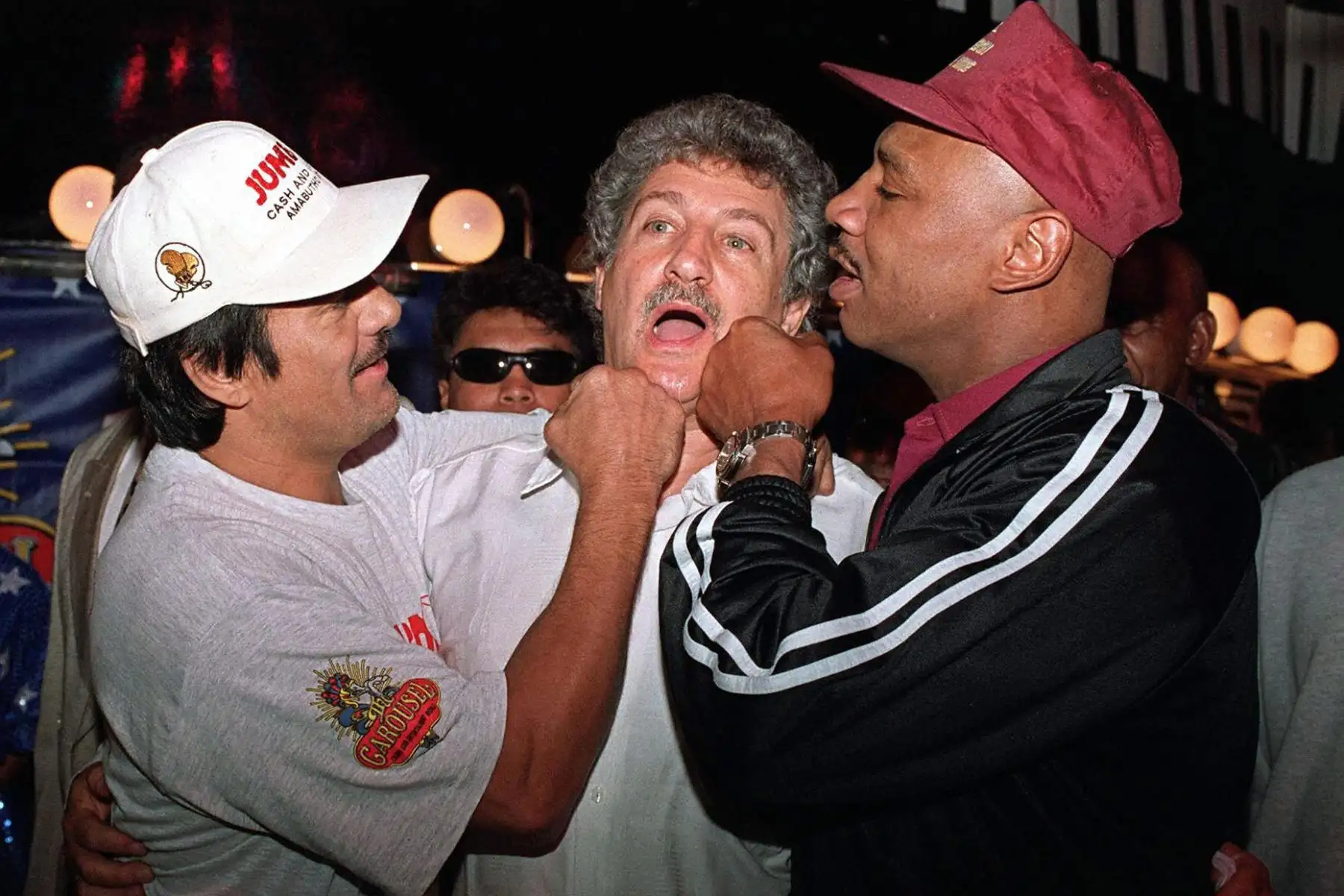 Los ex campeones mundiales de peso mediano de Estados Unidos, Roberto "Hands of Stone" Duran Y Marvin "Marvelous" Hangler Pretenden golpear al promotor de boxeo sudafricano Cedric Kushner, al norte de Pretoria. Duran debía haber peleado con su compatriota P.J. Goosen, quien tuvo que retirarse de la pelea debido a una lesión en el tobillo. 
Foto: AFP
