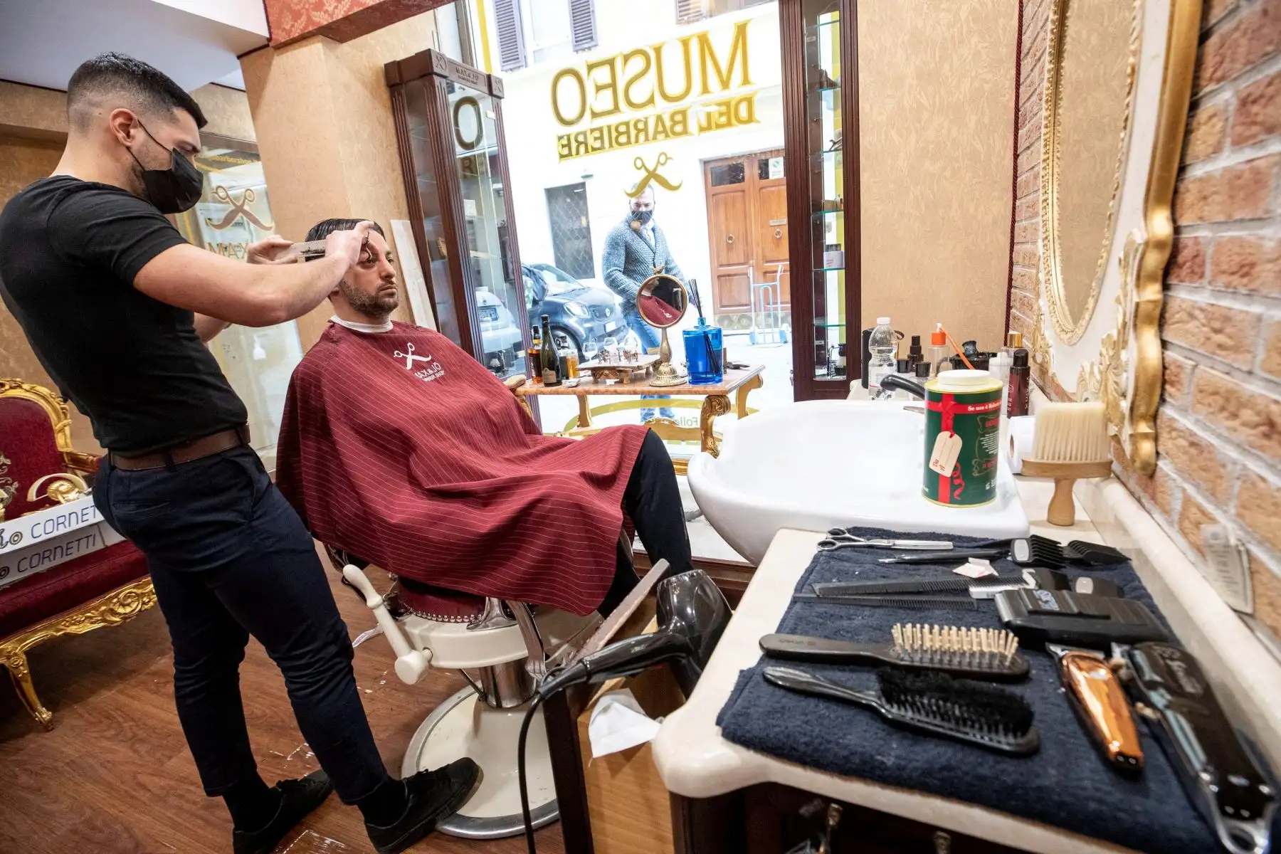 Un cliente está siendo atendido por un peluquero el último día antes de que entren en vigor las nuevas medidas estrictas contra la pandemia covid-19, en Roma, Italia.