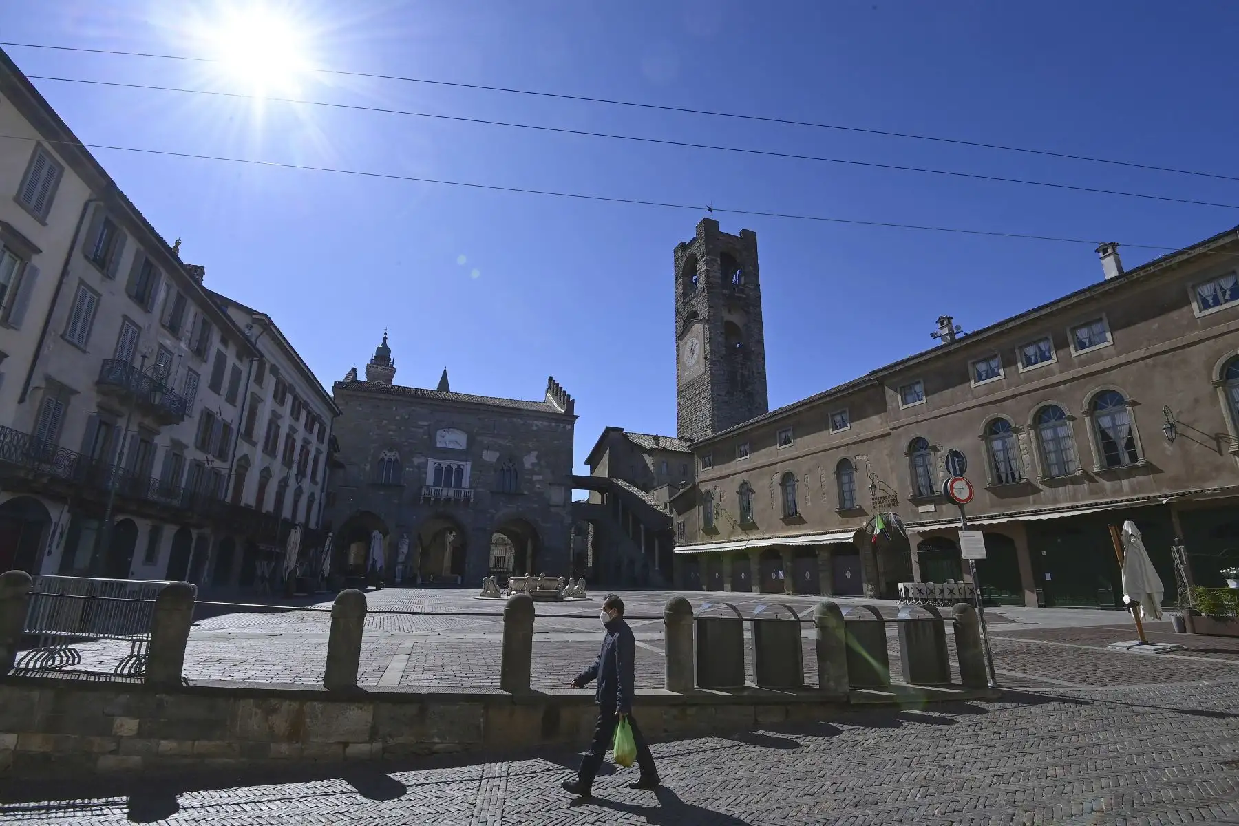 Un hombre camina por  la Plaza Vieja en la "Citta Alta" de Bérgamo mientras tres cuartas partes de los italianos entran en un bloqueo estricto para frenar los contagios de coronavirus. Foto: AFP