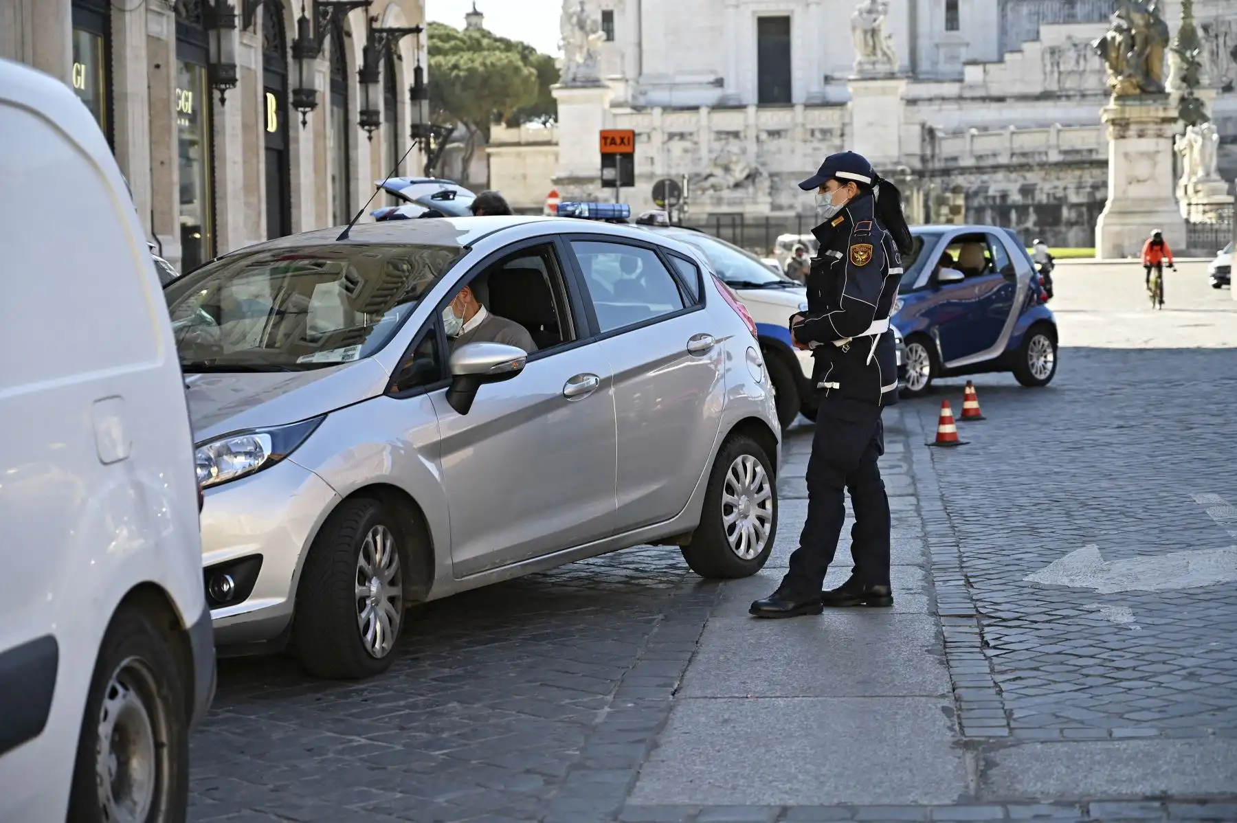 Una mujer policía municipal controla a un conductor en la plaza Piazza Venezia en el centro de Roma cuando tres cuartas partes de los italianos ingresaron a un estricto bloqueo para frenar los contagios por coronavirus. Foto: AFP