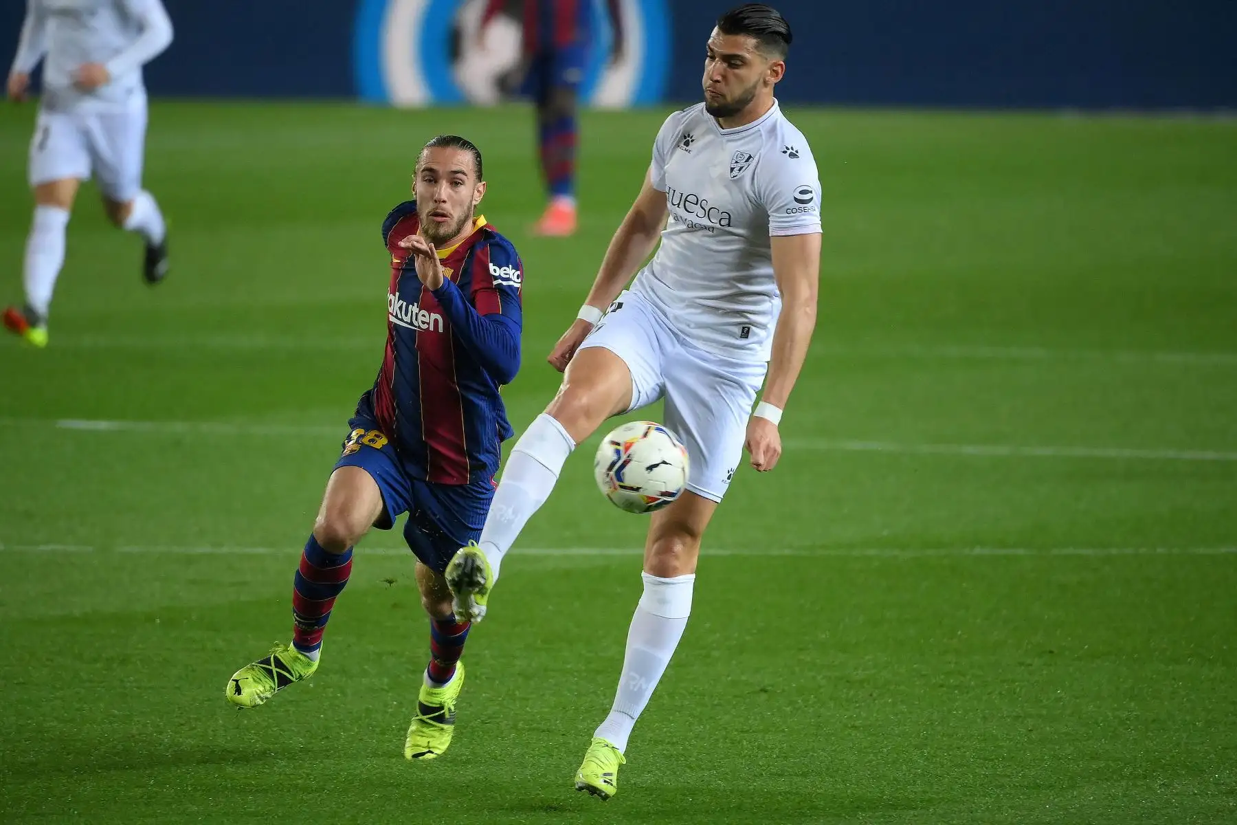 El defensa español del Barcelona Oscar Mingueza desafía al delantero español del Huesca Rafa Mir durante el partido de fútbol de la Liga española, en el Camp Nou. Foto: AFP
