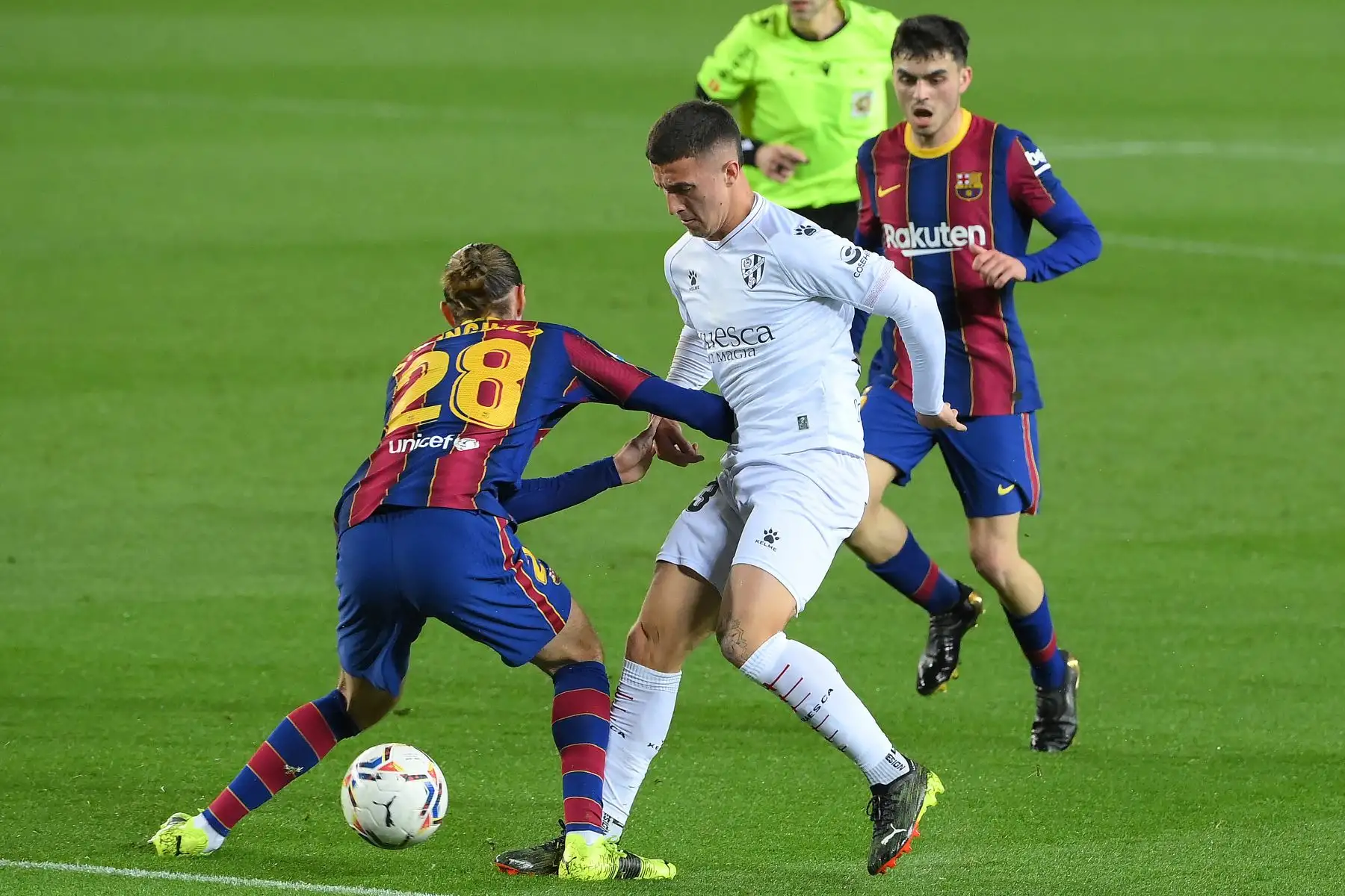 El defensor español del Huesca Pablo Maffeo desafía al defensor español del Barcelona Oscar Mingueza y al centrocampista español del Barcelona Pedri durante el partido de fútbol de la Liga española. Foto: AFP