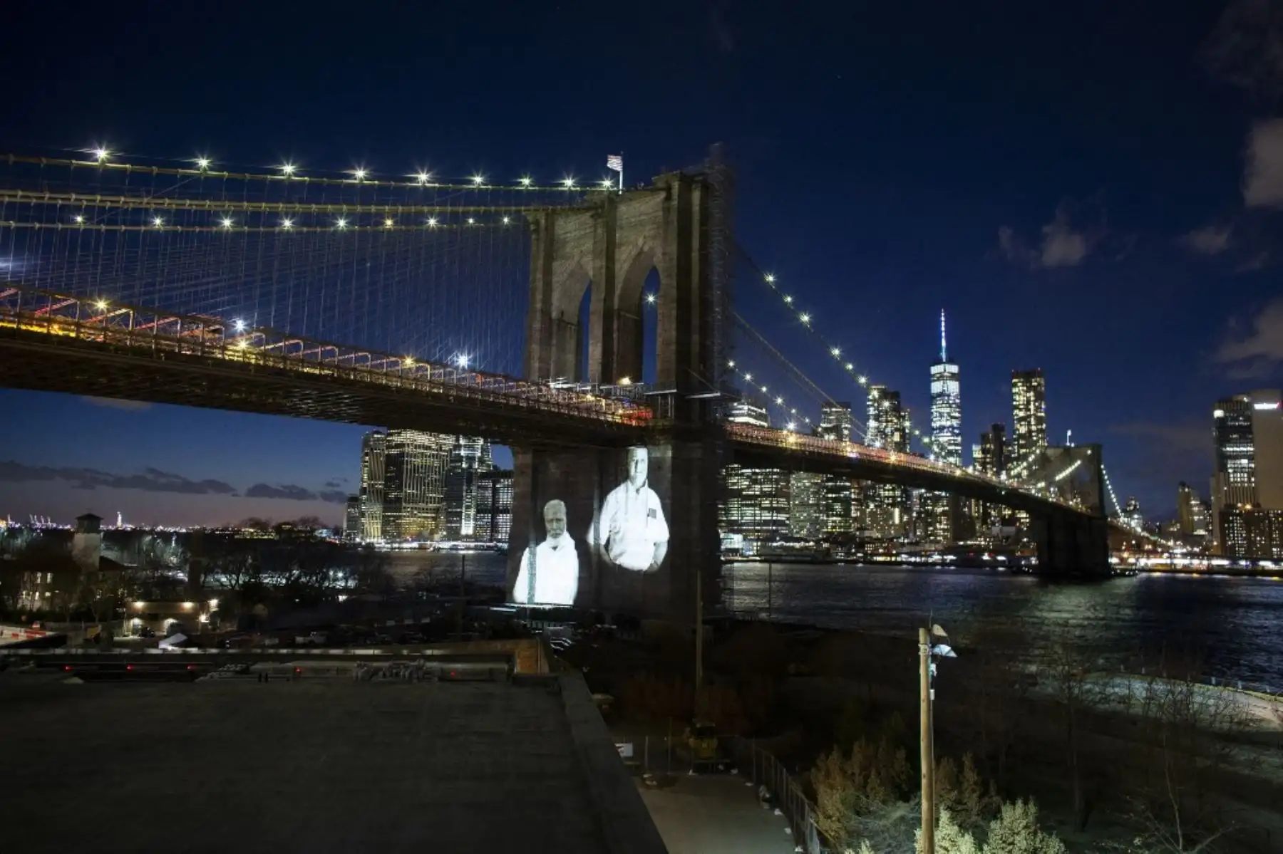 Las imágenes de las víctimas del covid-19 se proyectan sobre el puente de Brooklyn mientras la ciudad conmemora el Día del Recuerdo del covid-19 en Brooklyn, Nueva York. Foto: AFP