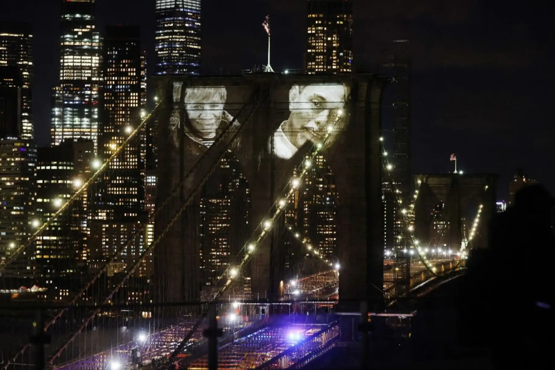 Las imágenes de las víctimas del covid-19 se proyectan sobre el puente de Brooklyn mientras la ciudad conmemora el Día del Recuerdo del covid-19 en Brooklyn, Nueva York. Foto: AFP