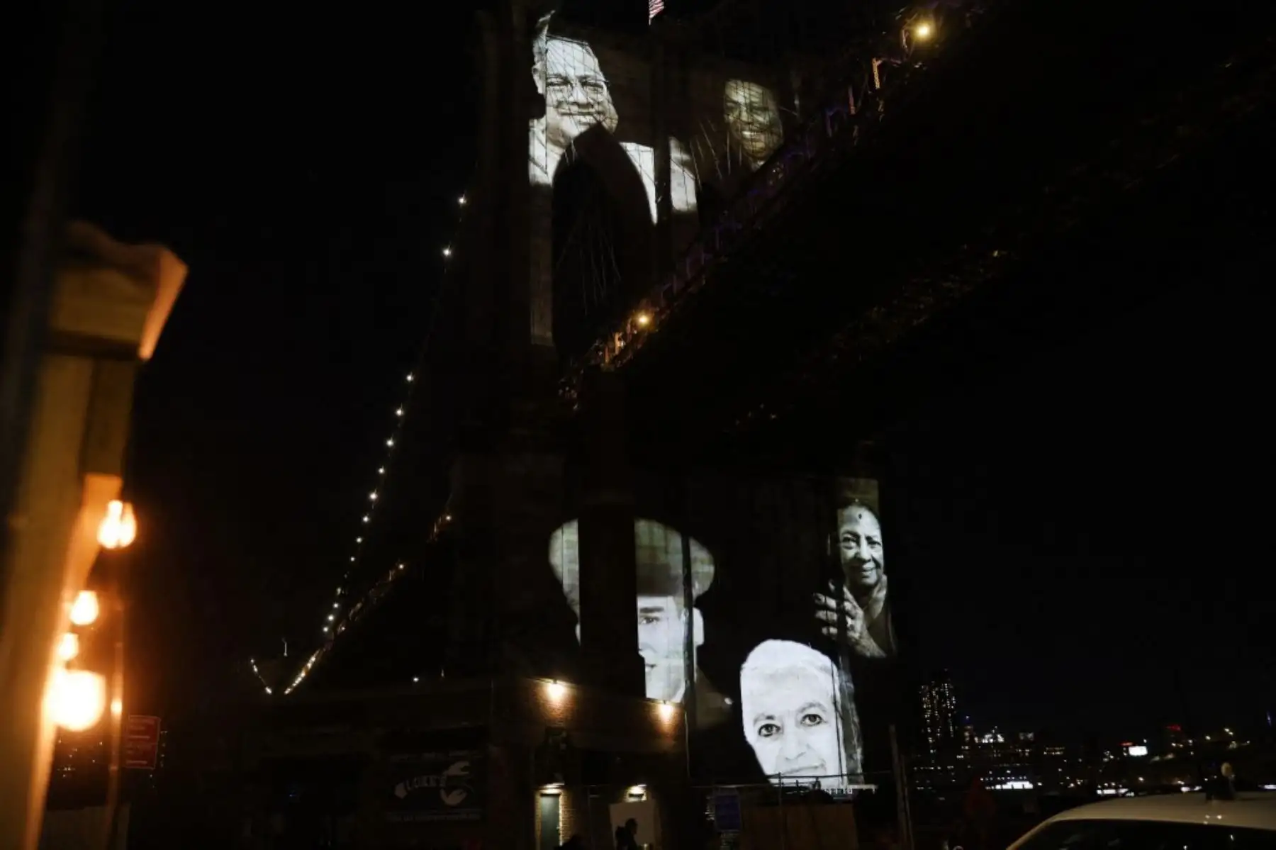 Las imágenes de las víctimas del covid-19 se proyectan sobre el puente de Brooklyn mientras la ciudad conmemora el Día del Recuerdo del covid-19 en Brooklyn, Nueva York. Foto: AFP