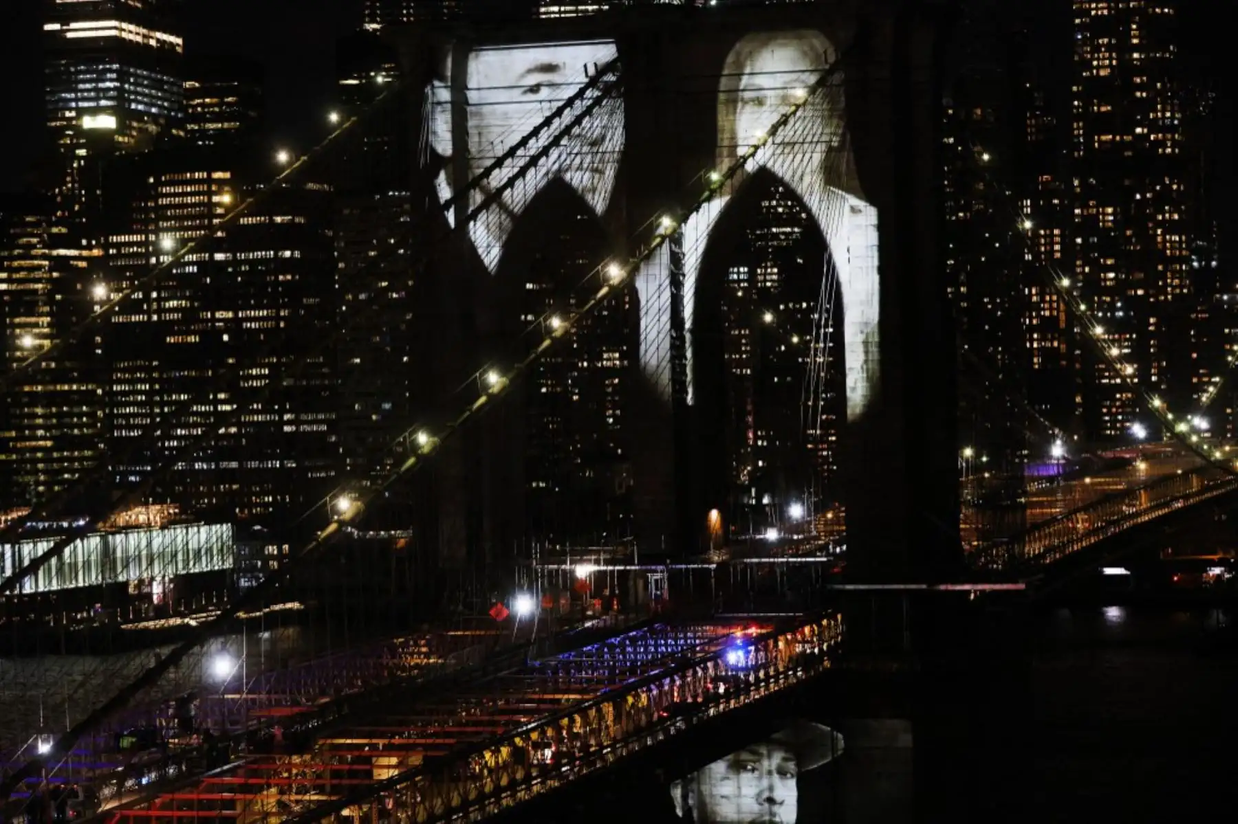 Las imágenes de las víctimas del covid-19 se proyectan sobre el puente de Brooklyn mientras la ciudad conmemora el Día del Recuerdo del covid-19 en Brooklyn, Nueva York. Foto: AFP