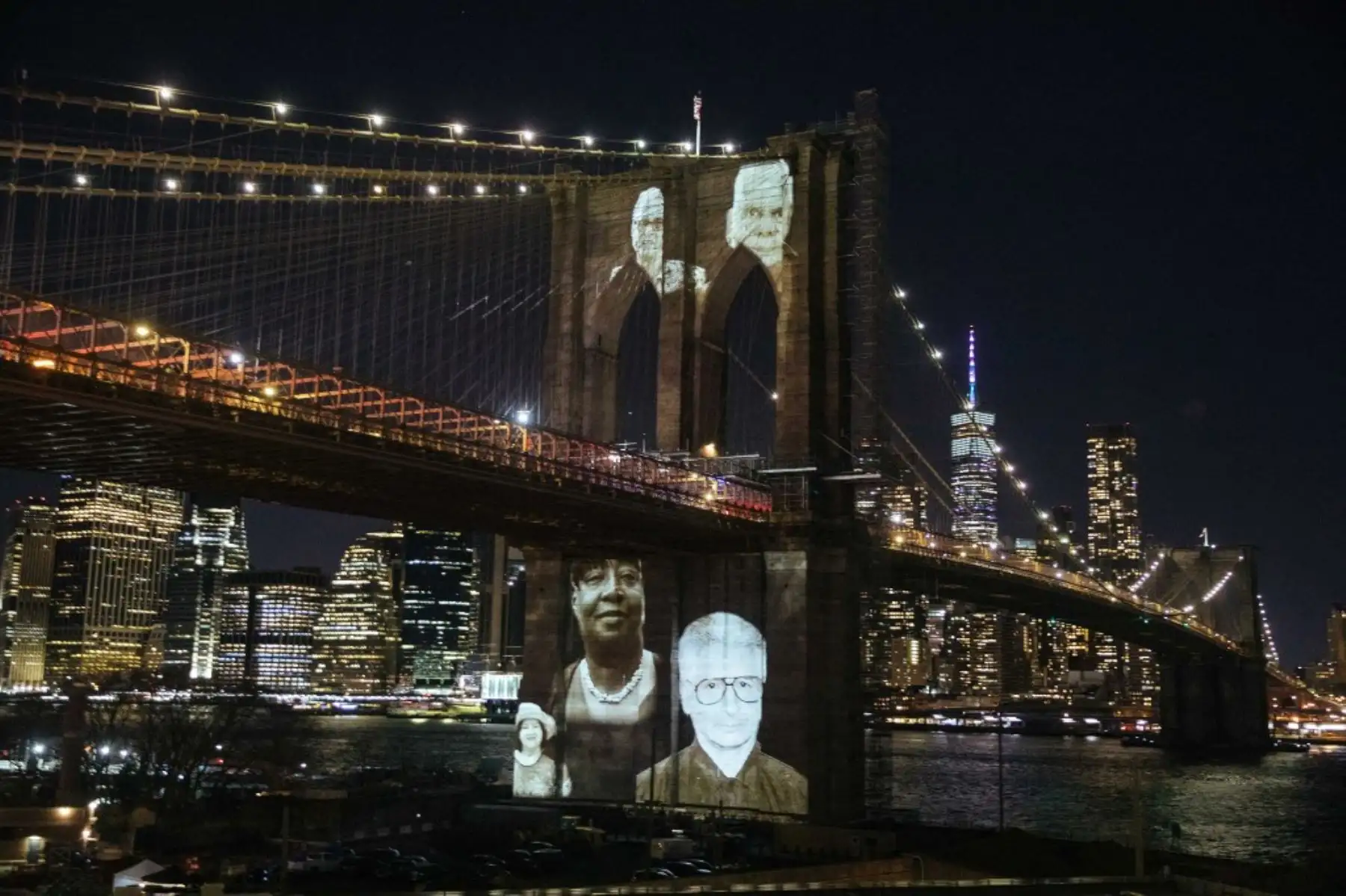 Las imágenes de las víctimas del covid-19 se proyectan sobre el puente de Brooklyn mientras la ciudad conmemora el Día del Recuerdo del covid-19 en Brooklyn, Nueva York. Foto: AFP