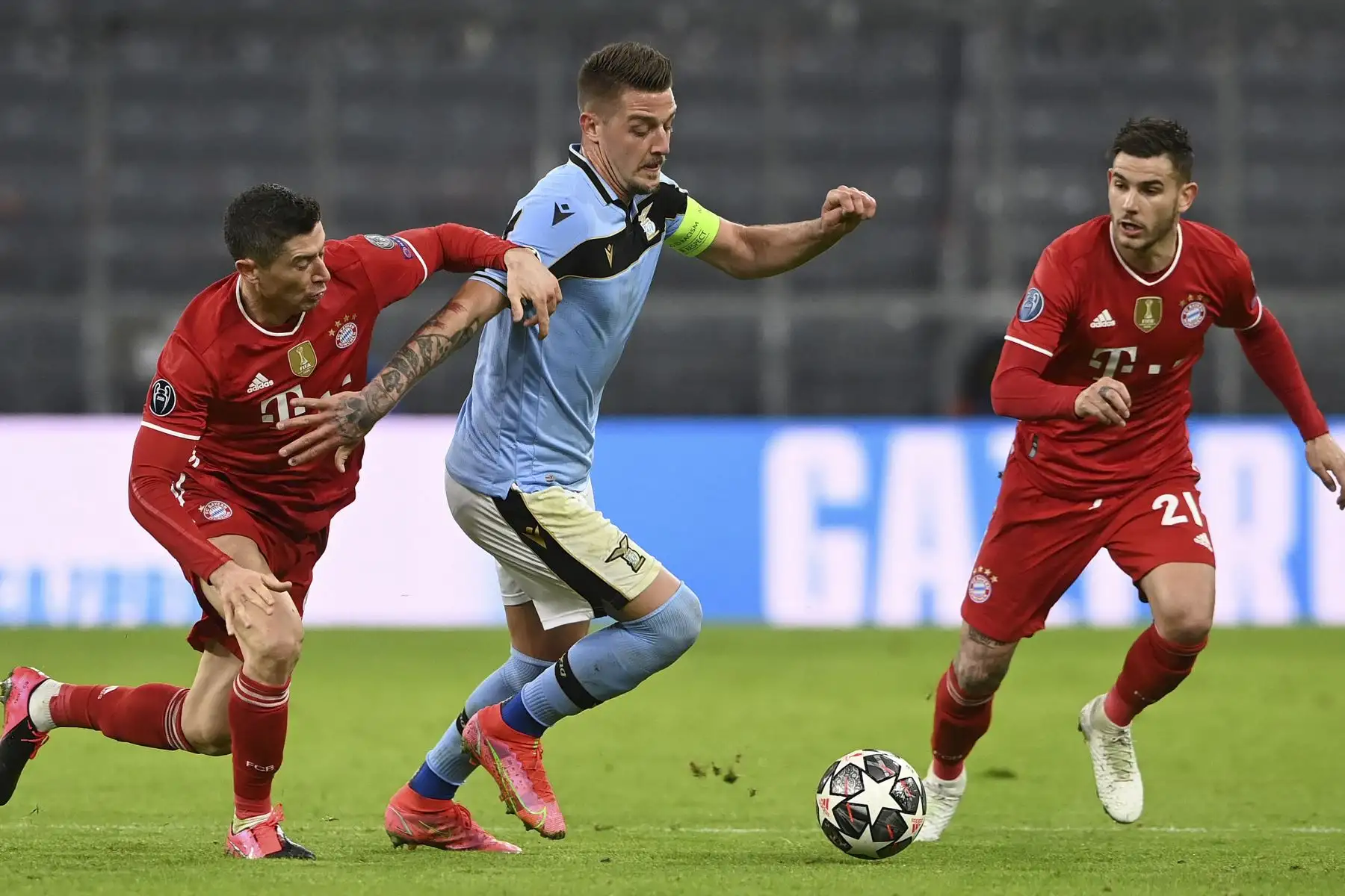 El delantero polaco del Bayern de Múnich Robert Lewandowski y el centrocampista serbio de Lazio Sergej Milinkovic-Savic compiten por el balón junto al defensor francés del Bayern de Múnich, Lucas Hernández, durante partido por  la Liga de Campeones. Foto: AFP