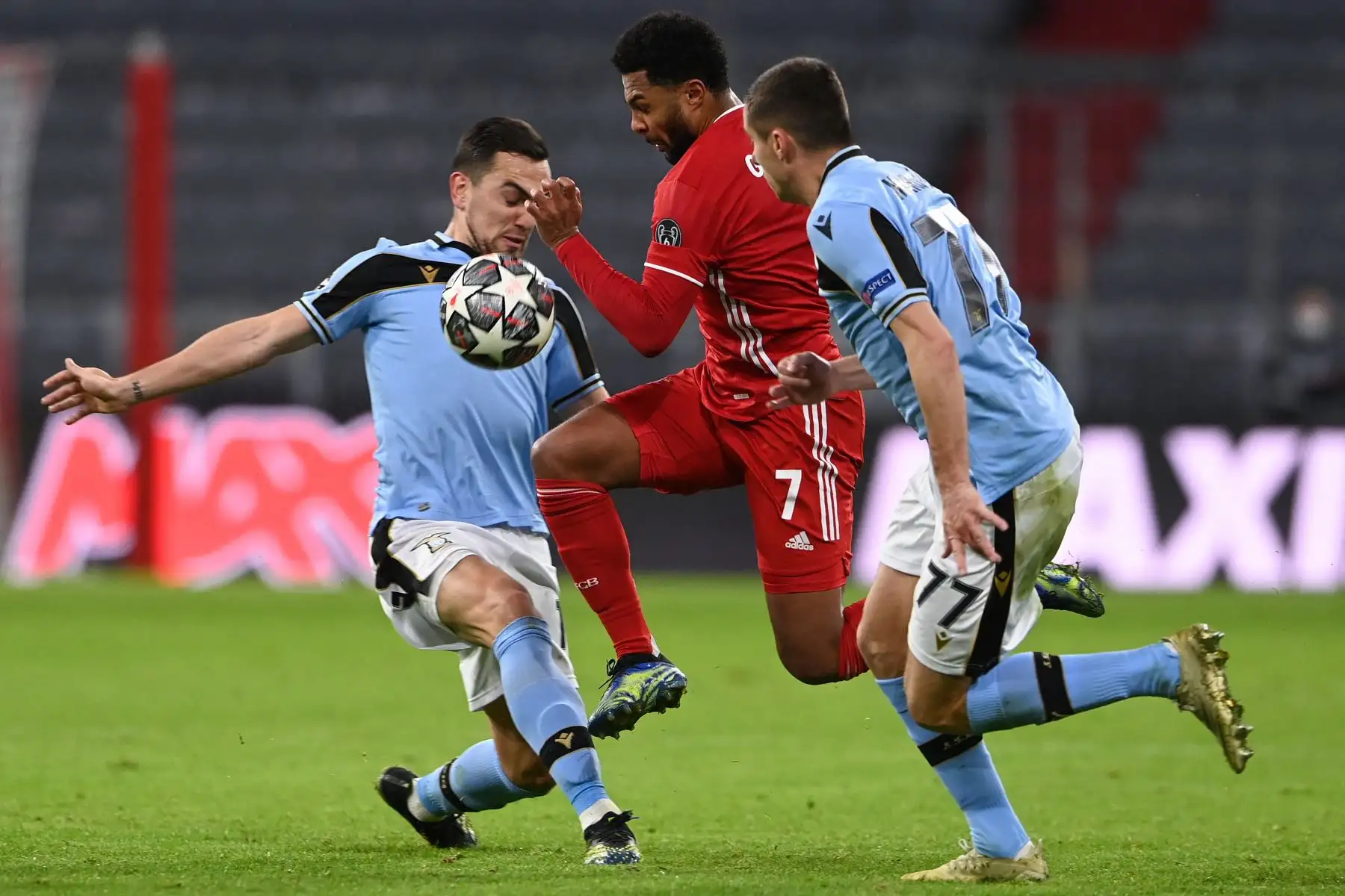 El centrocampista alemán del Bayern de Múnich Serge Gnabry rompe con la marca del centrocampista argentino de Lazio Gonzalo Escalante  y el centrocampista montenegrino Adam Marusic durante los octavos de final de la UEFA Champions League. Foto: AFP