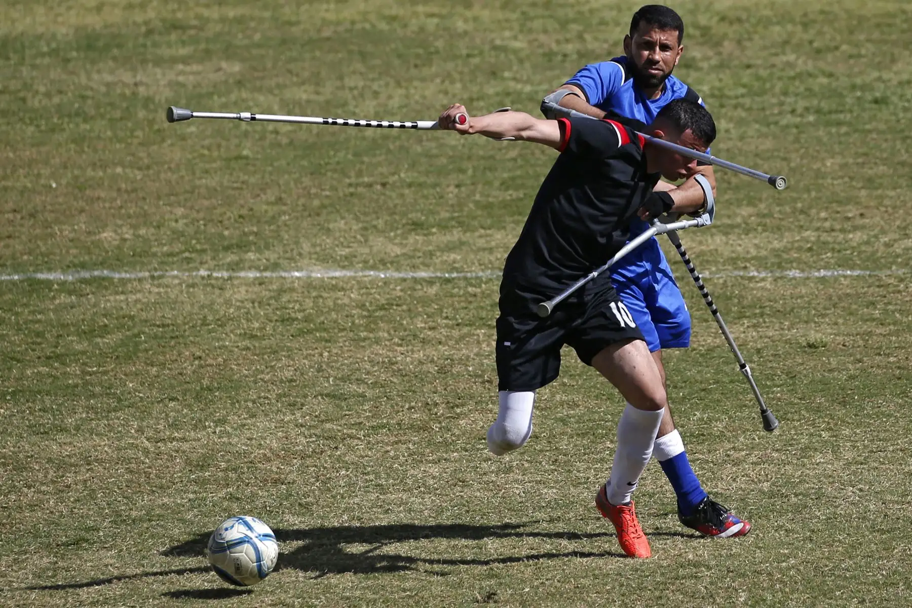 Jugadores palestinos compiten durante la final de un campeonato local de fútbol para amputados entre Al-Jazeera (kit negro) y Al-Abtal, organizado por el Comité Internacional de la Cruz Roja (CICR), en la ciudad de Gaza. Foto: AFP