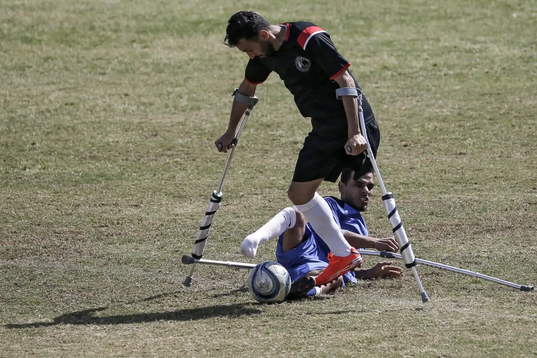 Jugadores palestinos compiten durante la final de un campeonato local de fútbol para amputados entre Al-Jazeera (kit negro) y Al-Abtal, organizado por el Comité Internacional de la Cruz Roja (CICR), en la ciudad de Gaza. Foto: AFP