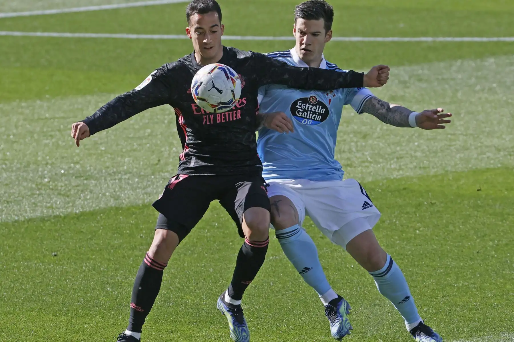 El delantero del Celta de Vigo Santi Mina pelea un balón con el defensa del Real Madrid Lucas Vázquez durante el partido de LaLiga Santander que se disputa en el estadio de Balaídos en Vigo. 
Foto: EFE