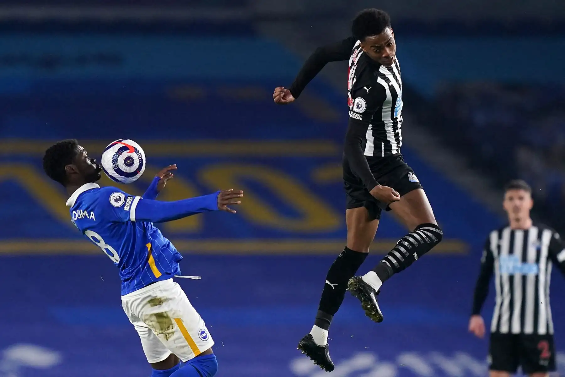 El centrocampista marfileño de Brighton Yves Bissouma (L) controla el balón bajo la presión del centrocampista inglés del Newcastle United Joe Willock (R) durante el partido de fútbol de la Premier League inglesa entre Brighton y Hove Albion y Newcastle United en el American Express Community Stadium en Brighton. Foto: AFP