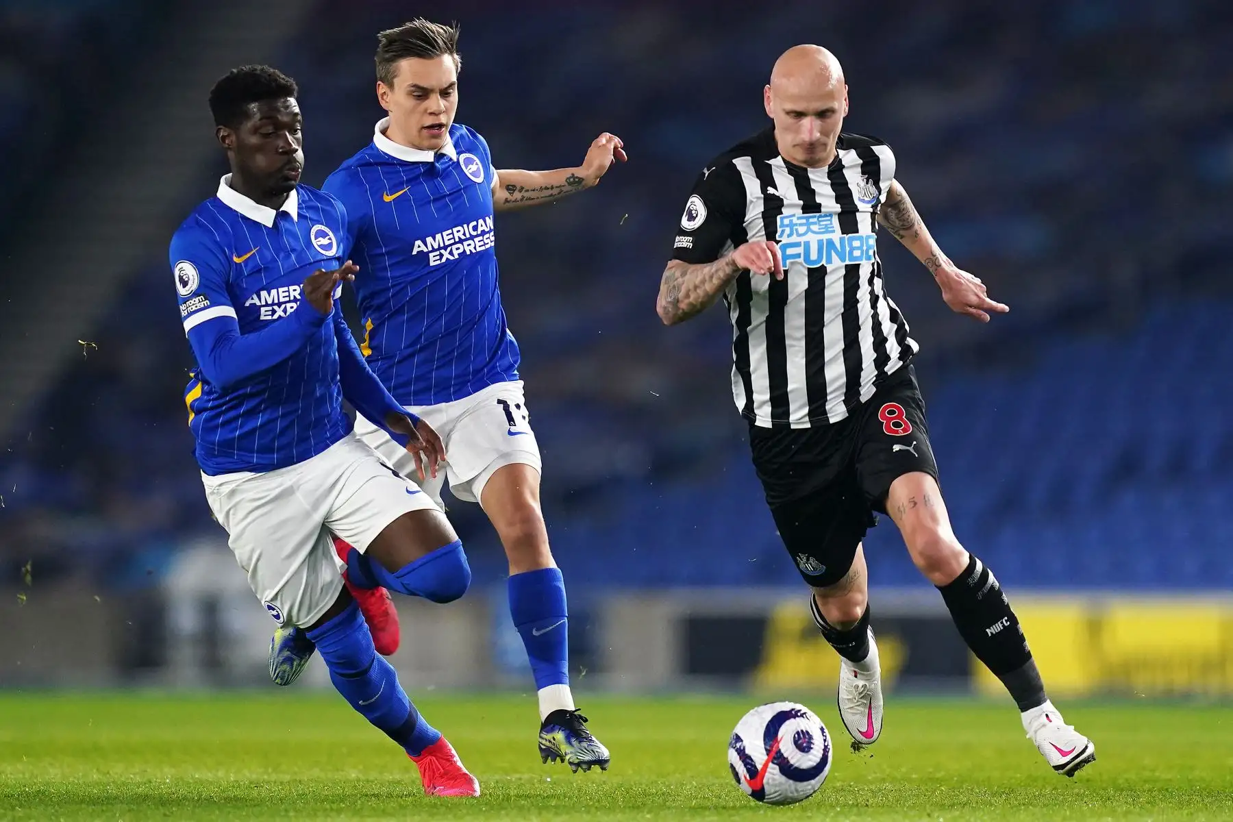 El centrocampista marfileño de Brighton Yves Bissouma (L), el centrocampista belga de Brighton Leandro Trossard (C) y el centrocampista inglés del Newcastle United Jonjo Shelvey (R) compiten por el balón durante el partido de fútbol de la Premier League inglesa entre Brighton y Hove Albion y Newcastle United en el American Express Community Stadium en Brighton, sur de Inglaterra. Foto: AFP