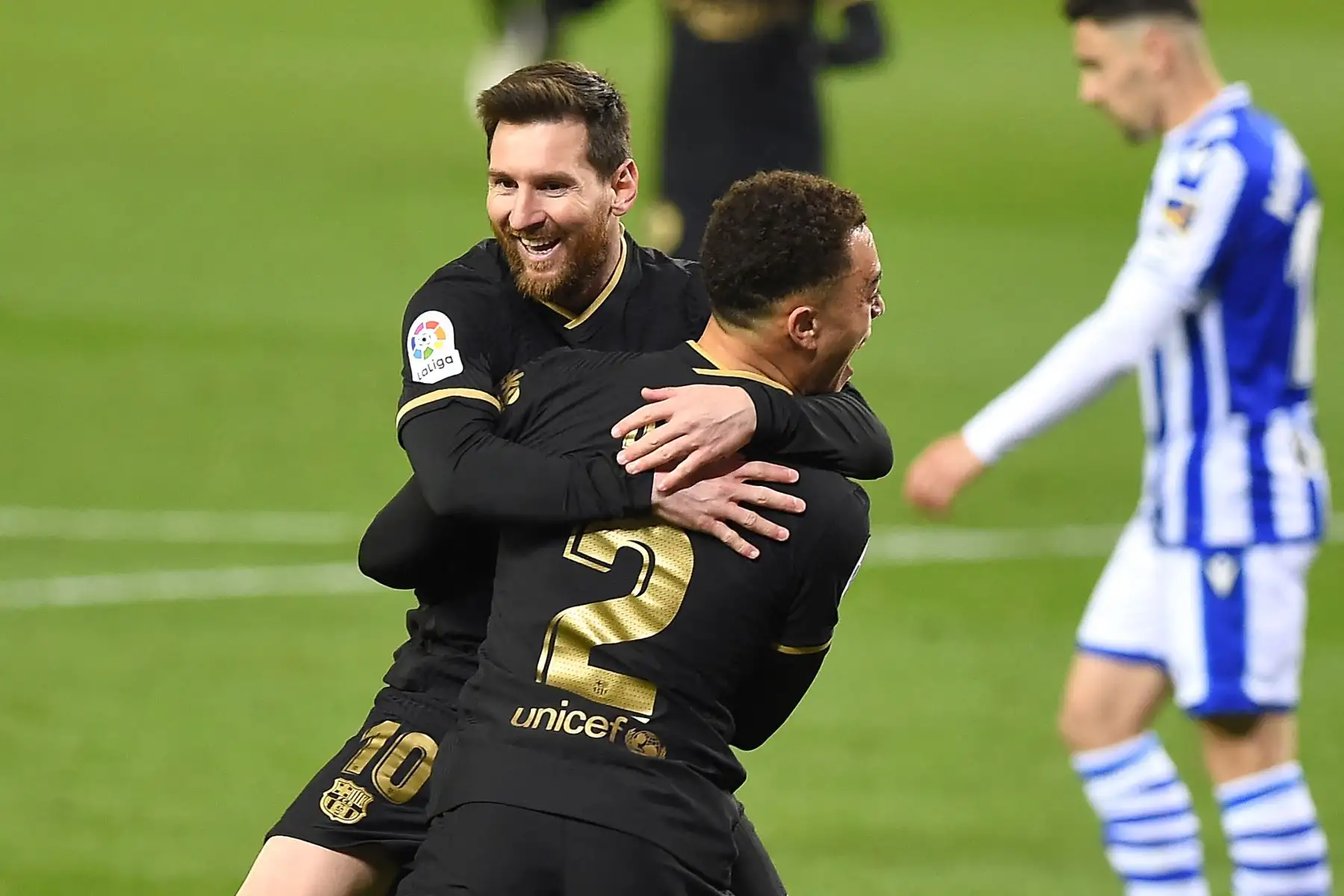 El defensa estadounidense del Barcelona del Barcelona Sergino Dest celebra con el delantero argentino del Barcelona Lionel Messi (atrás) tras marcar un gol durante el partido de fútbol de la Liga española entre la Real Sociedad y el Barcelona en el estadio de Anoeta en San Sebastián. Foto: AFP