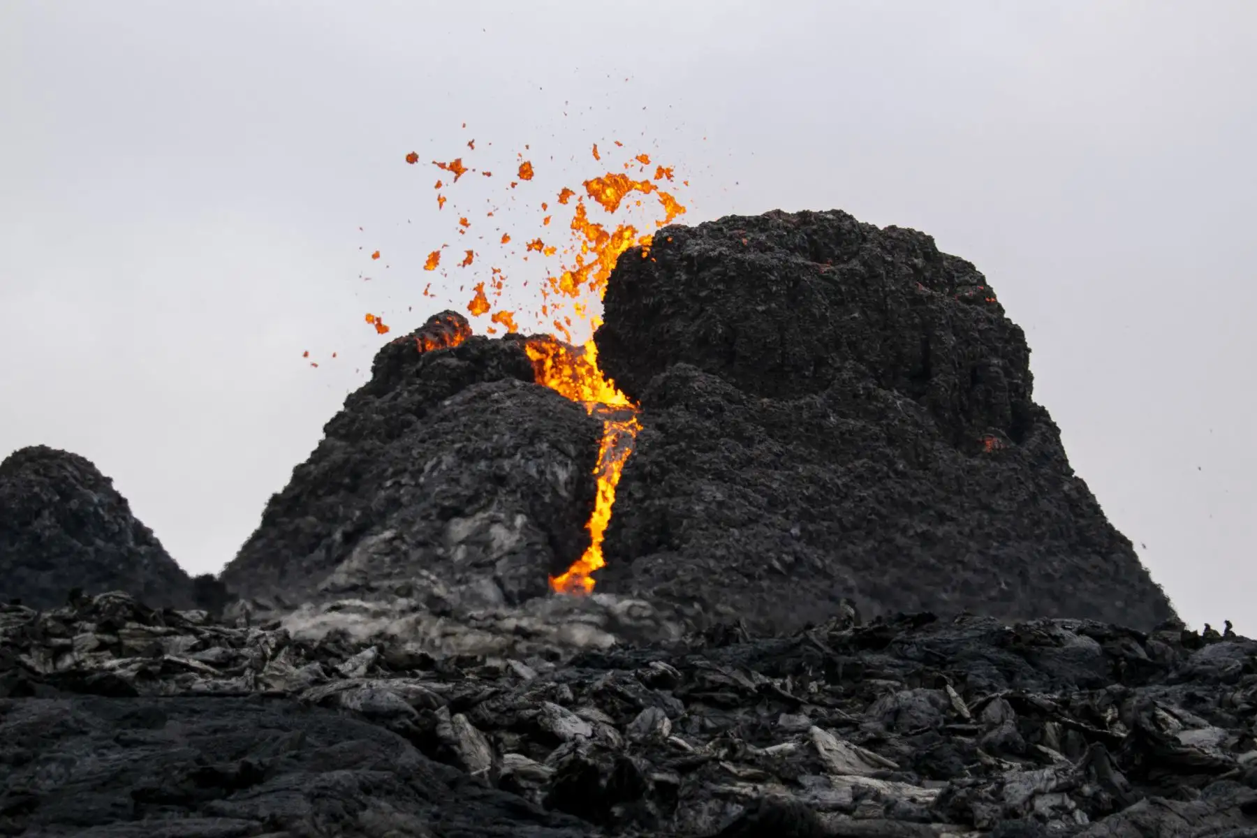 A pocos metros de la lava, miles de curiosos contemplan hipnotizados el espectáculo de la erupción de un volcán en las laderas del monte Fagradalsfjall, cerca de la capital de Islandia. Foto: AFP
