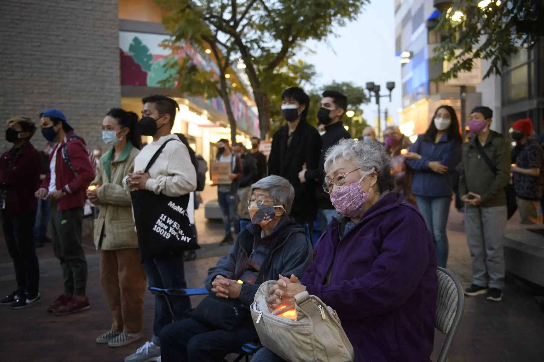 Las personas que usan mascarillas sostienen velas durante una vigilia conmemorativa para los residentes de un hogar de ancianos que murieron debido al Covid-19 el 20 de marzo de 2021 en el vecindario de Little Tokyo en Los Ángeles, California. Foto: AFP