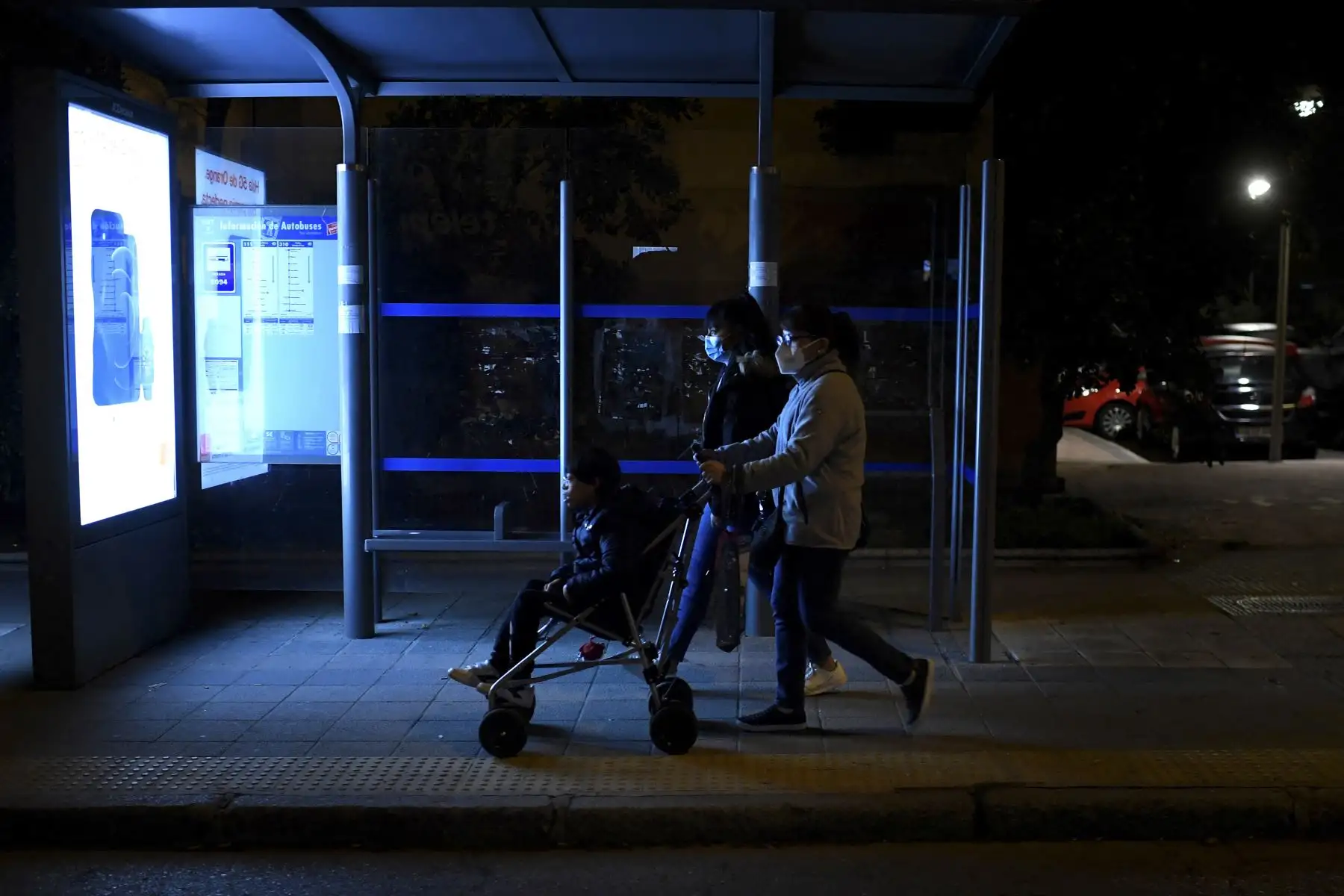 Amanda Gómez, de 53 años, empuja el cochecito de su hijo Guillermo mientras camina hacia el hospital con su hija mayor, Alejandra. Foto: AFP