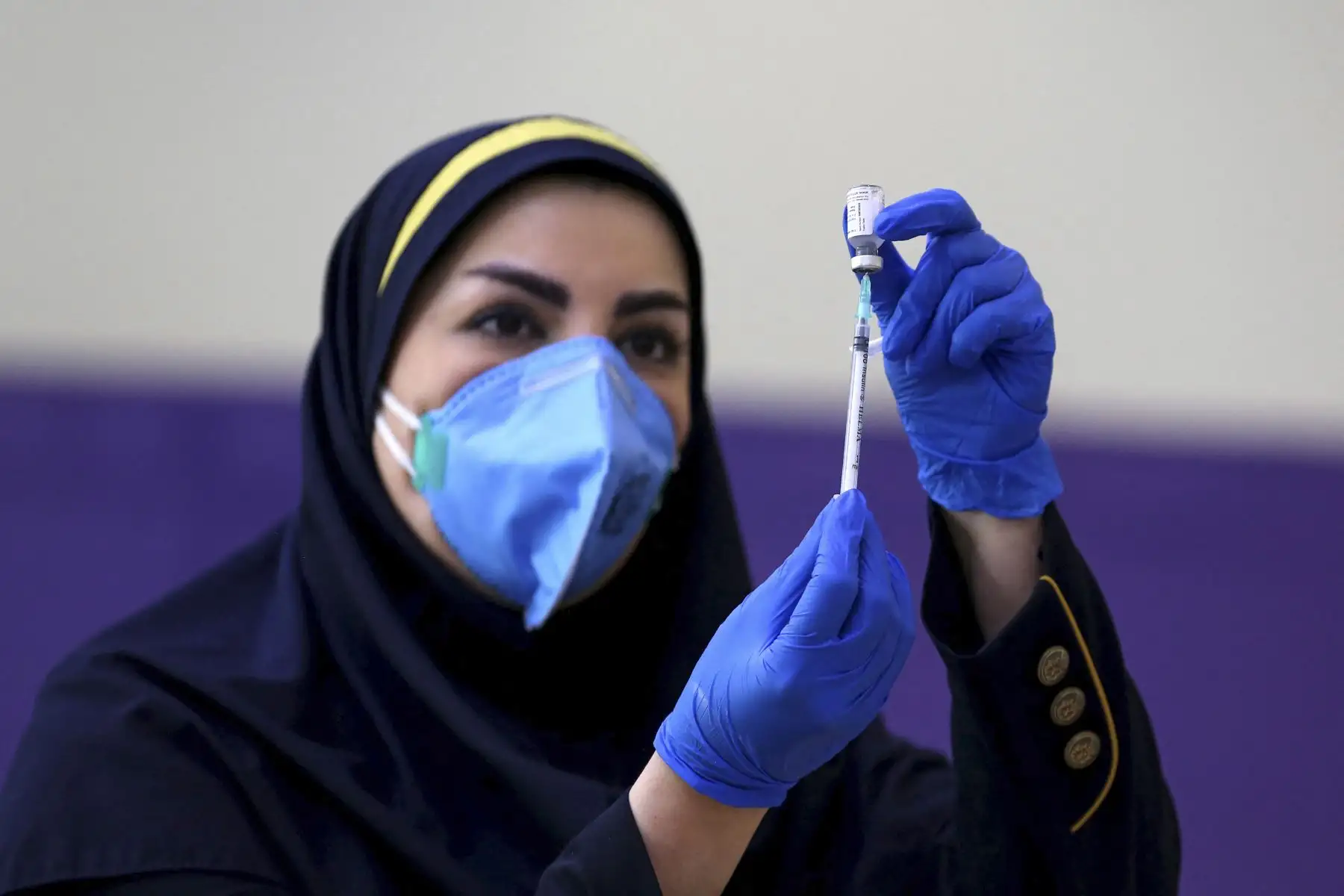 Un trabajador de la salud iraní prepara una inyección de la vacuna COVID-19 de fabricación local durante el inicio de la segunda fase de ensayos en la capital, Teherán, el 15 de marzo de 2021. Foto: AFP