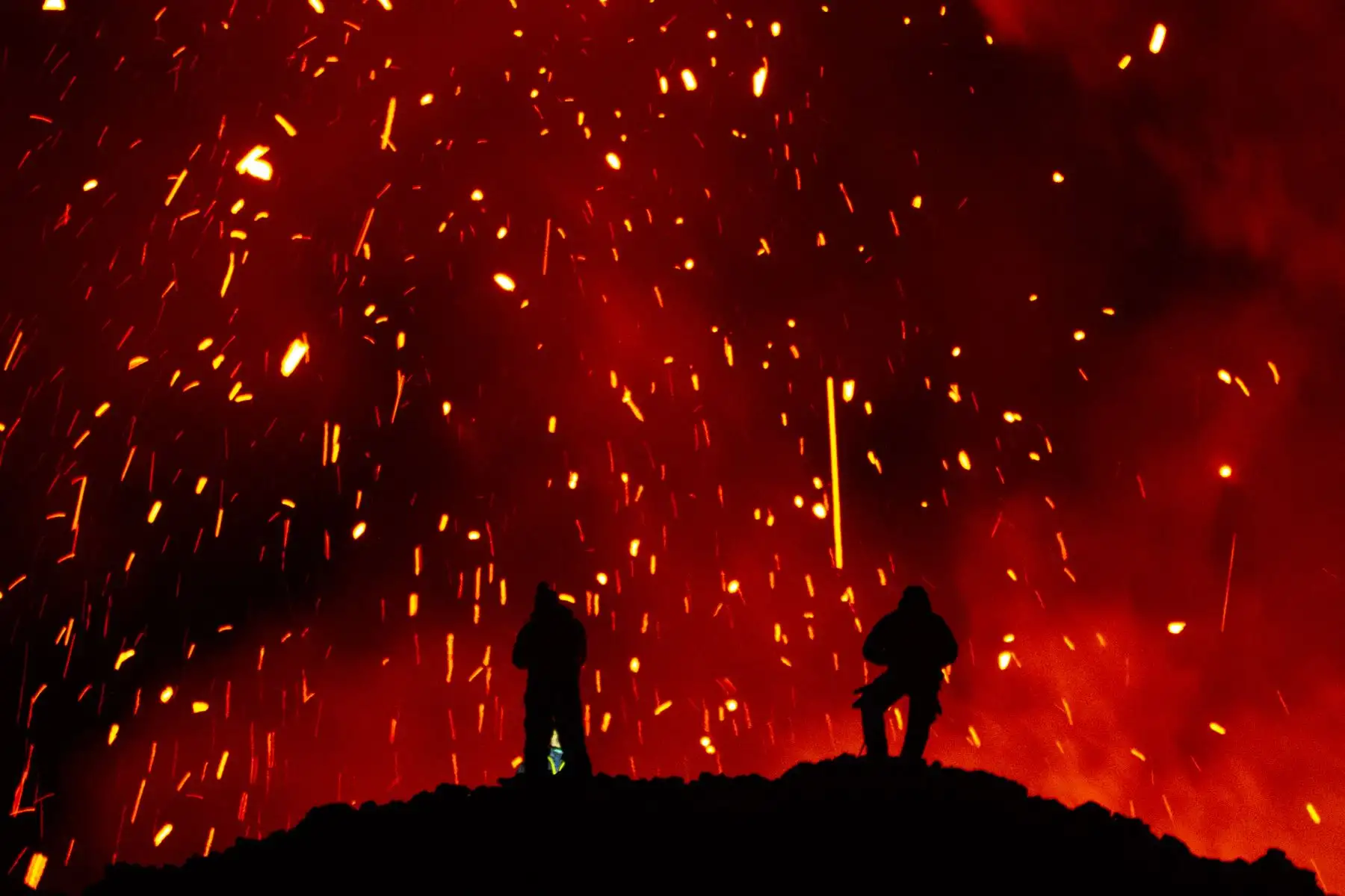 Una fotografía tomada el 16 de marzo de 2021 muestra a personas observando la erupción del volcán Klyuchevskoy en la península de Kamchatka, en el extremo oriental de Rusia. Foto: AFP