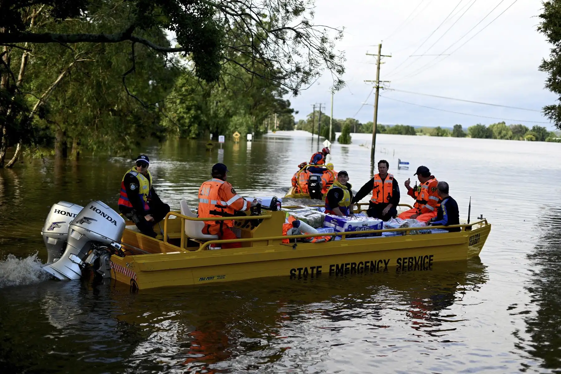 Los miembros del Servicio de Emergencia del Estado y la policía transportan suministros médicos y artículos de socorro para los residentes afectados por las inundaciones durante las operaciones de rescate en Windsor, en el noroeste de Sydney. Foto: AFP