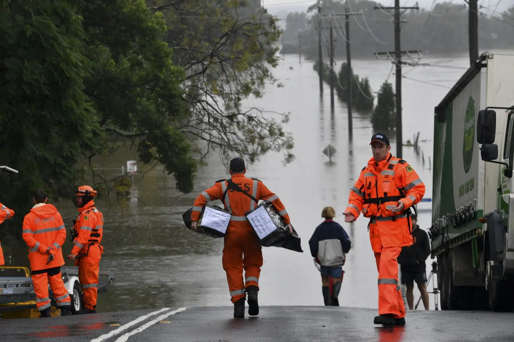 Los miembros del Servicio de Emergencia del Estado llevan suministros médicos durante una operación de rescate en un área residencial inundada en el suburbio de Windsor. Foto: AFP