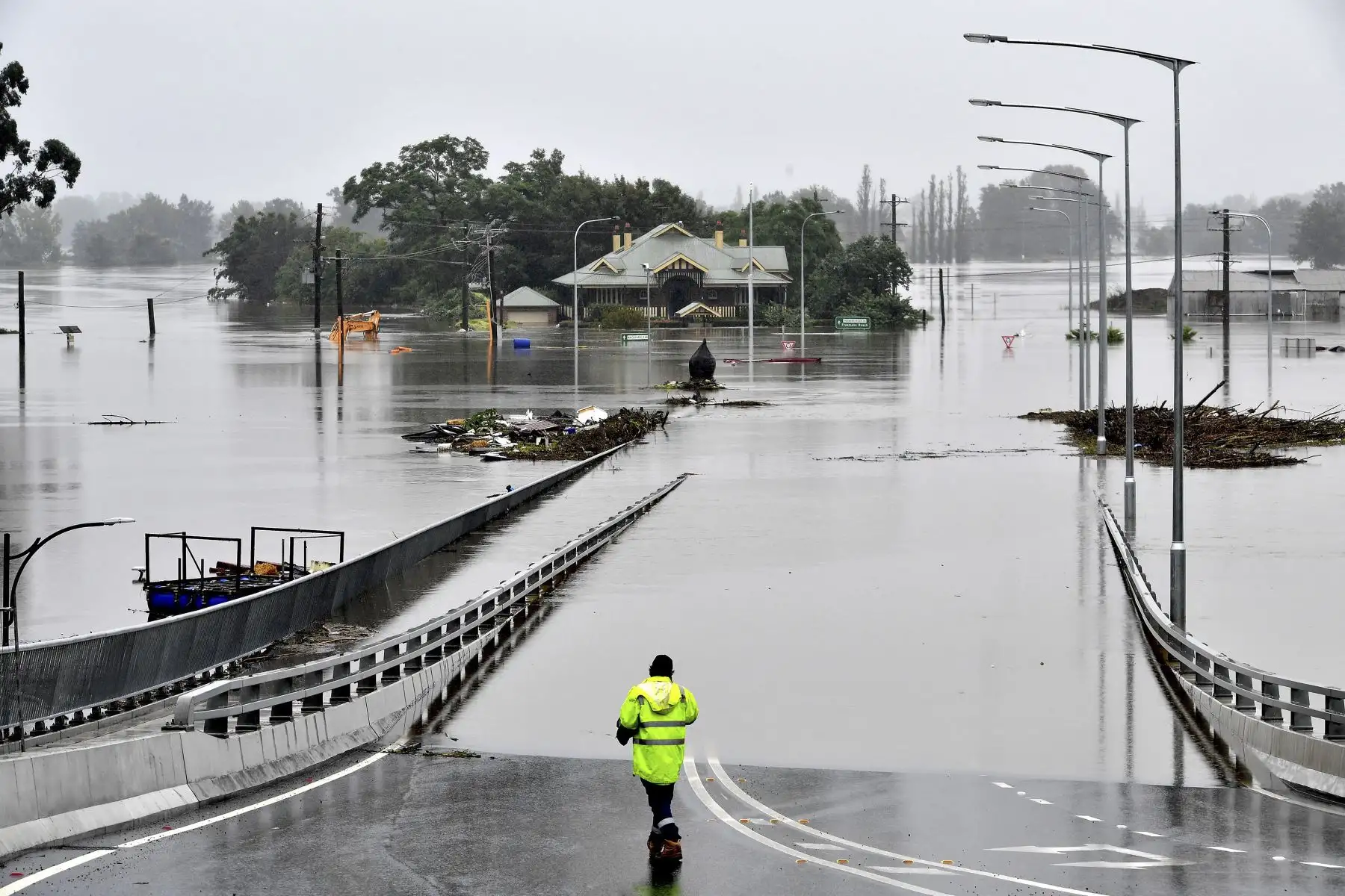 Un rescatista observa la entrada del Puente Windsor al noroeste de Sydney, en Australia, luego que las torrenciales lluvias lo inundara por completo. Foto: AFP