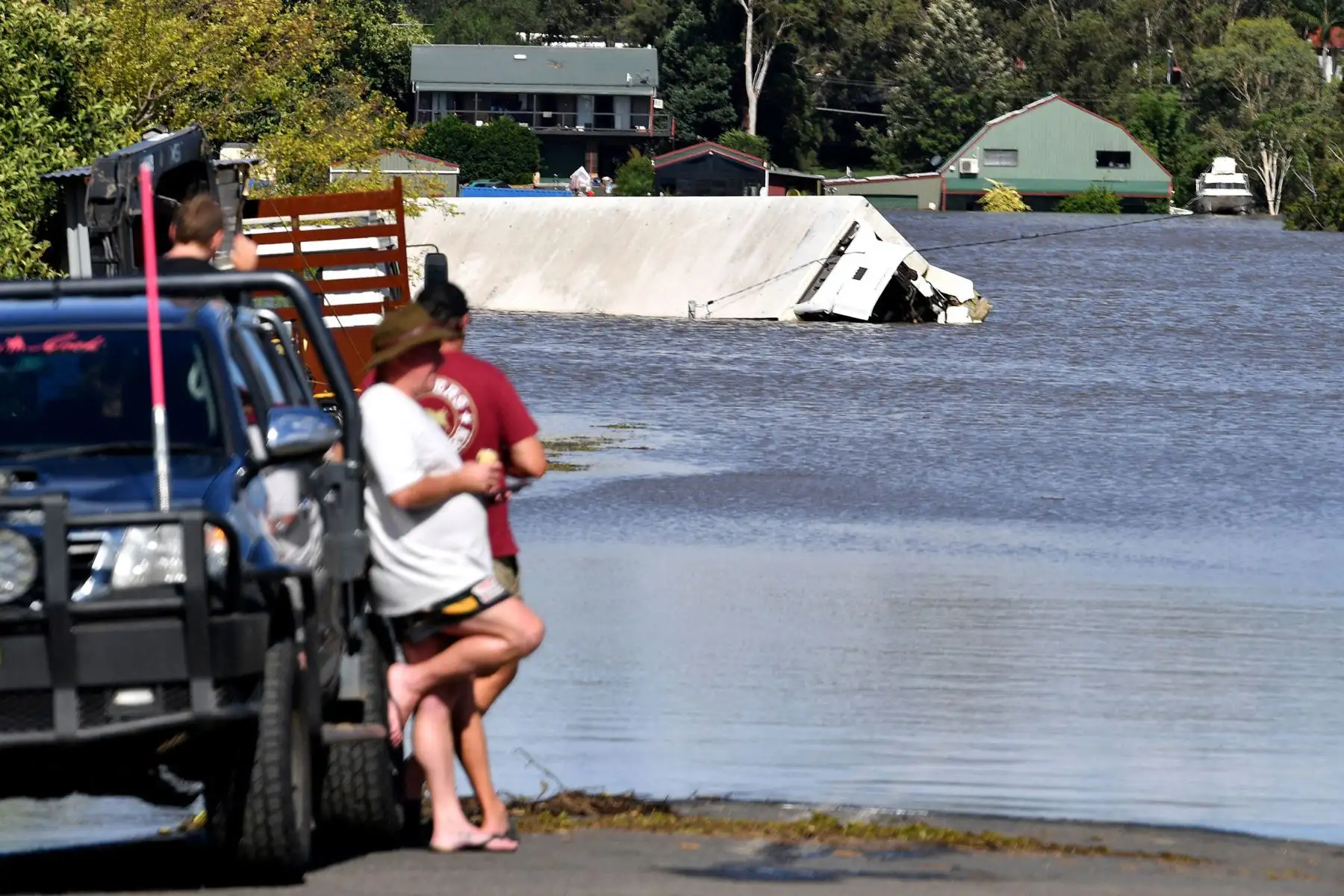 La gente mira un contenedor rodeado de inundaciones en una zona residencial del suburbio de Windsor en el noroeste de Sydney, después de que lluvias torrenciales azotaran el sureste de Australia durante días.
Foto:  AFP