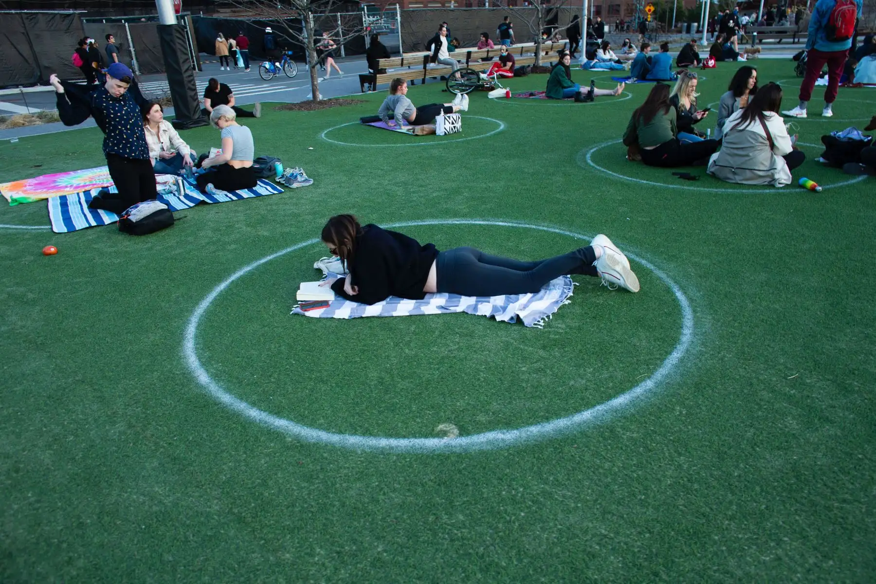 Se ven círculos de distanciamiento social cuando la gente visita Domino Park en Brooklyn mientras la ciudad de Nueva York experimenta temperaturas cálidas. Foto: AFP