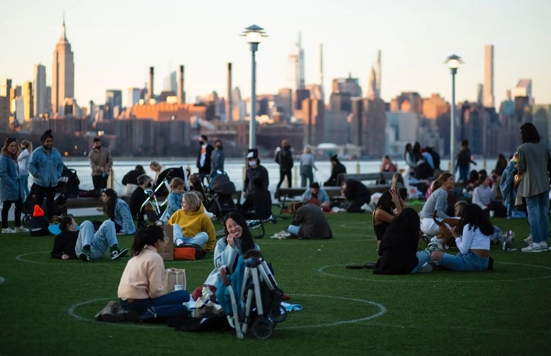 Se ven círculos de distanciamiento social cuando la gente visita Domino Park en Brooklyn mientras la ciudad de Nueva York experimenta temperaturas cálidas. Foto: AFP