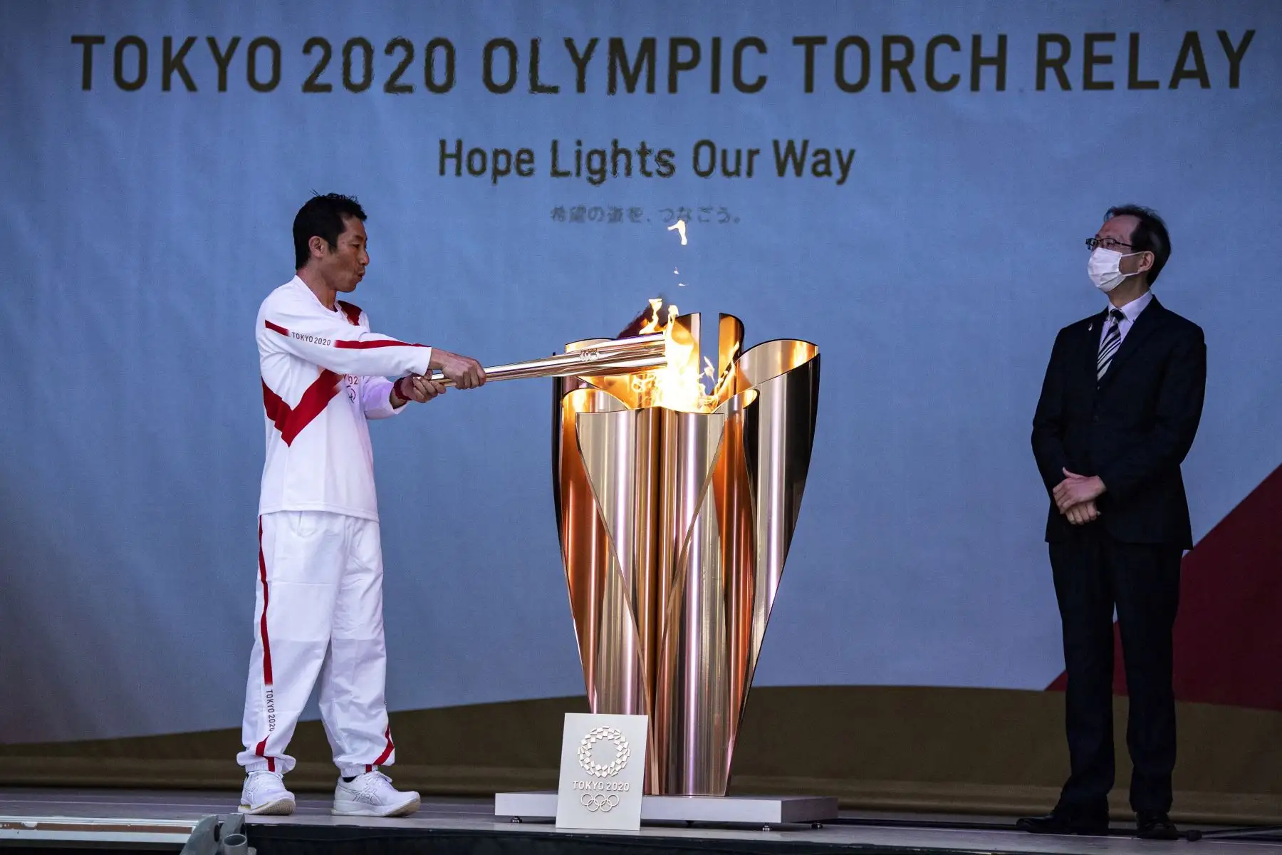 El piloto japonés de acrobacias aéreas Yoshihide Muroya lleva una antorcha cuando llega al sitio del festival de Hibarigahara, durante la última etapa del primer día del relevo de la antorcha olímpica de Tokio 2020 en Minamisoma, Prefectura de Fukushima. Foto: AFP