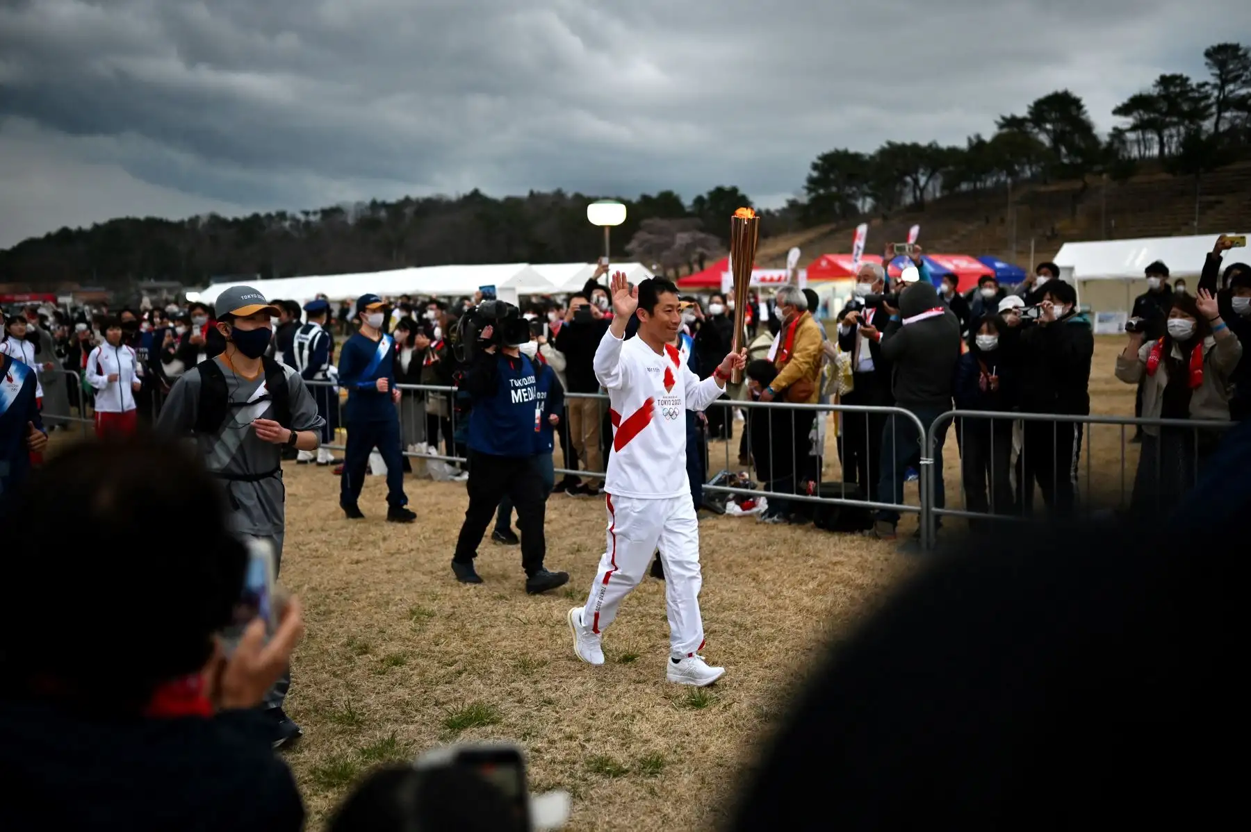 El piloto japonés de acrobacias aéreas Yoshihide Muroya lleva una antorcha cuando llega al sitio del festival de Hibarigahara, durante la última etapa del primer día del relevo de la antorcha olímpica de Tokio 2020 en Minamisoma, Prefectura de Fukushima. Foto: AFP