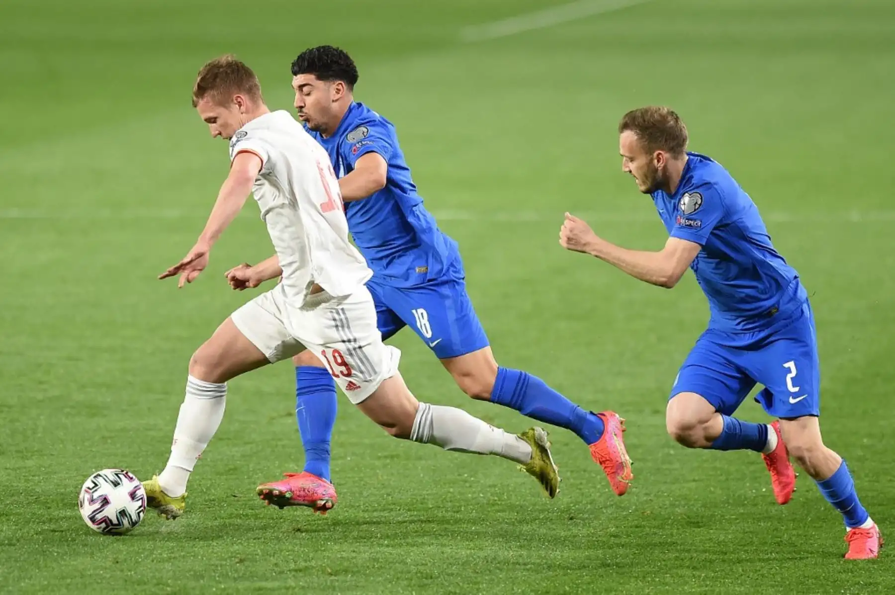 El defensor griego Michalis Bakakis  y el centrocampista griego Dimitrios Limnios desafían al delantero español Dani Olmo en partido de clasificación de la Copa Mundial de la FIFA Qatar 2022 entre España y Grecia, en el estadio de Los Cármenes de Granada. Foto: AFP