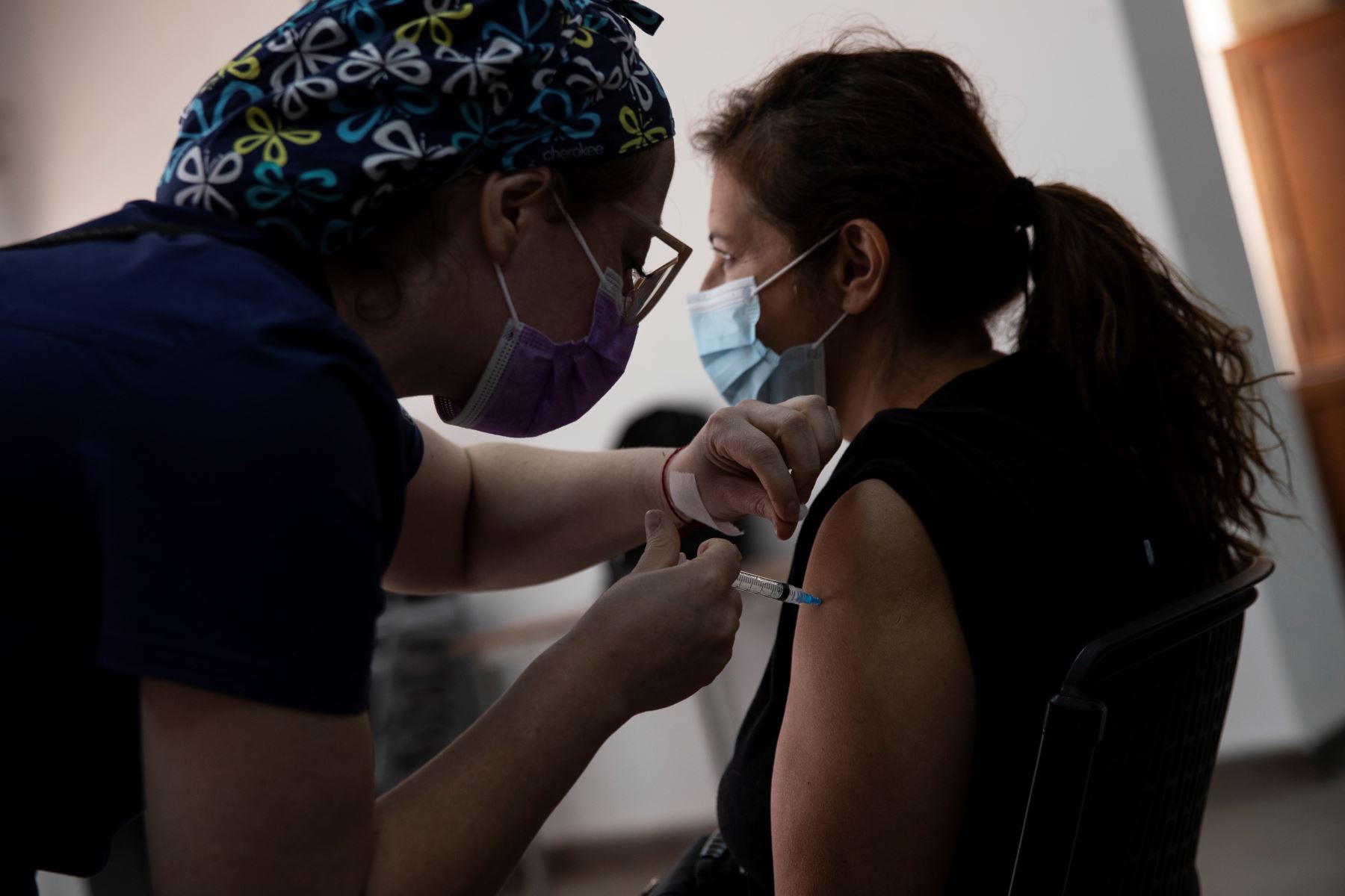 Una enfermera le administra a un hombre una de las dosis de la vacuna de BioNTech, Pfizer, contra la Covid-19 hoy, en un centro deportivo de Santiago (Chile). Foto: AFP