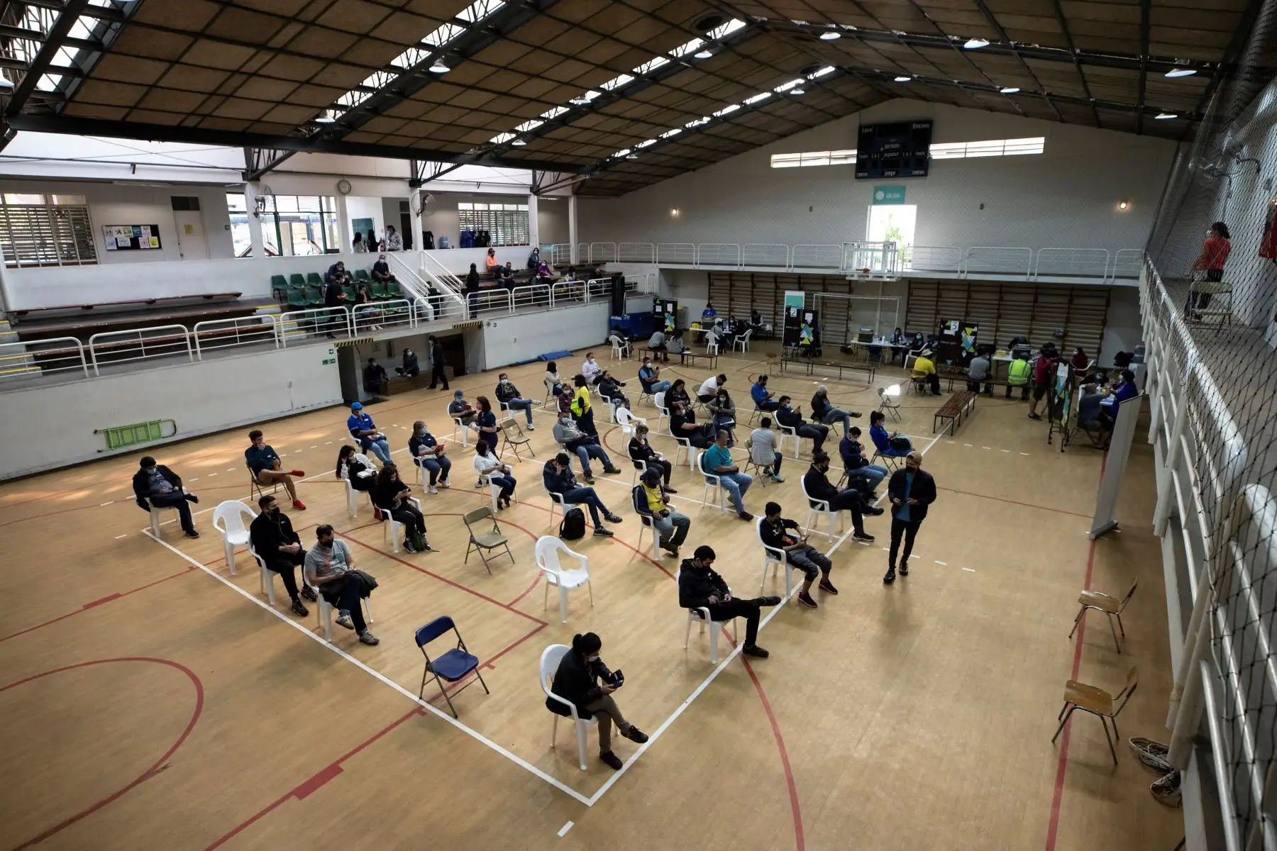 Un grupo de personas espera en reposo tras recibir una de las dosis de la vacuna de BioNTech, Pfizer, contra la Covid-19 hoy, en un centro deportivo de Santiago (Chile). Foto: AFP