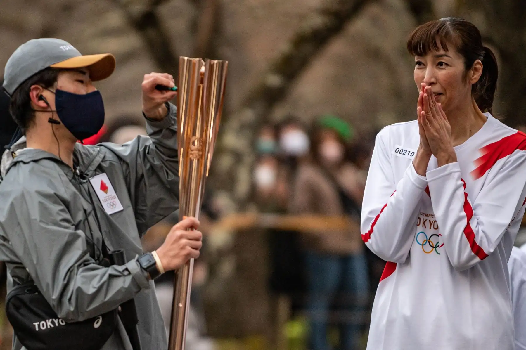 Un miembro del personal de Tokio 2020 ajusta la antorcha del portador de la antorcha japonés Motoko Obayashi, ex jugador olímpico de voleibol, durante la última etapa del segundo día del relevo de la antorcha de los Juegos Olímpicos de Tokio 2020 en el Castillo Tsurugajo en la ciudad de Aizuwakamatsu.
Foto: AFP