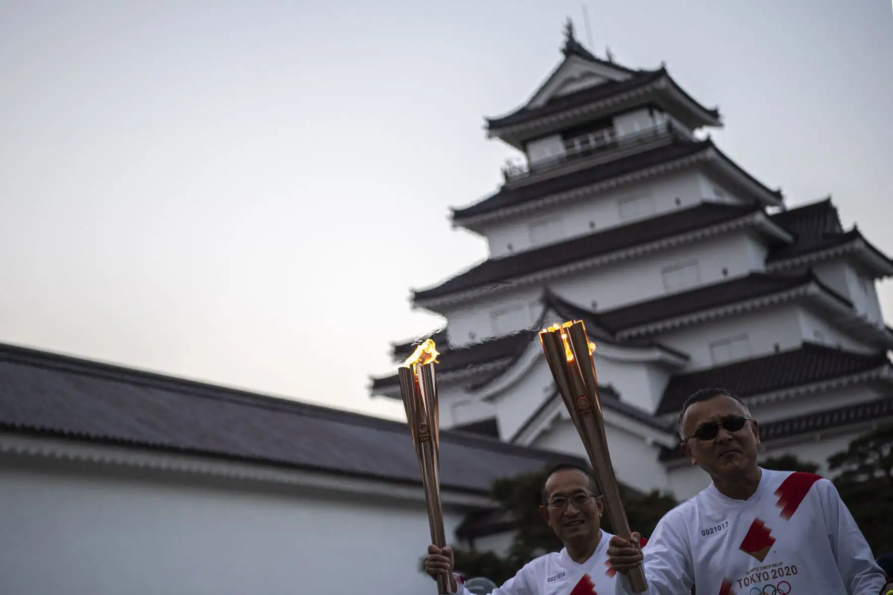 Los portadores de la antorcha Yoshitake Sato y Kikuchi Mashitsu miran un punto de beso de la antorcha durante la última etapa del segundo día del relevo de la antorcha de los Juegos Olímpicos de Tokio 2020 en el Castillo de Tsurugajo en la ciudad de Aizuwakamatsu.
Foto:AFP