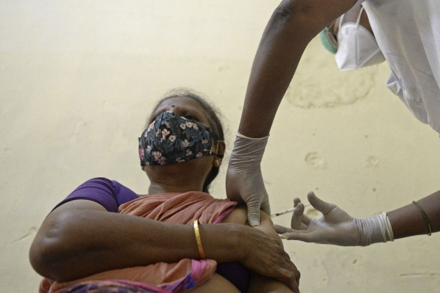 Un trabajador médico inocula a una anciana con la vacuna contra el coronavirus covid-19 en un hospital del gobierno en Hyderabad. Foto: AFP