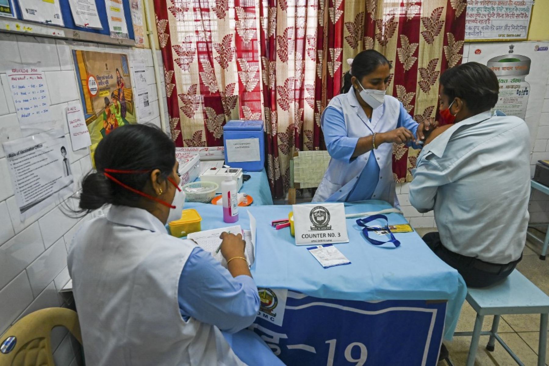 Un trabajador médico inocula a un hombre con la vacuna contra el coronavirus covid-19 en un centro de vacunación en Nueva Delhi. Foto: AFP