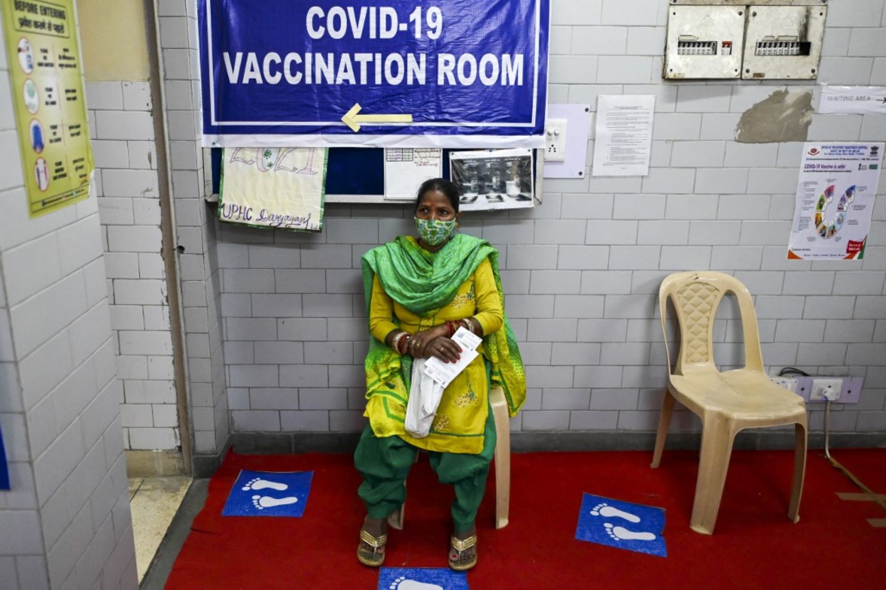 Una mujer espera recibir una vacuna contra el coronavirus covid-19 en un centro de salud en Nueva Delhi. Foto: AFP