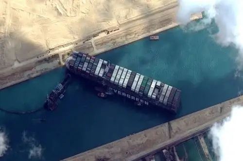 El Ever Given quedó encallado en una orilla del canal y atravesado en el tramo sur a la altura del kilómetro 151 debido a los fuertes vientos y falta de visibilidad por una tormenta de arena que azotó Egipto a principios de esta semana. Foto: AFP