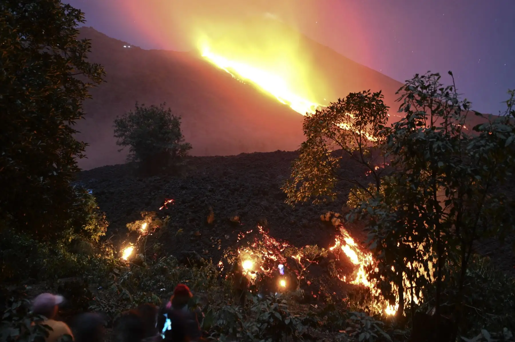 La gente observa cómo fluye lava del volcán Pacaya desde la finca La Breña, en el municipio San Vicente, a unos 60 kilómetros al sur de la ciudad de Guatemala. Foto: AFP