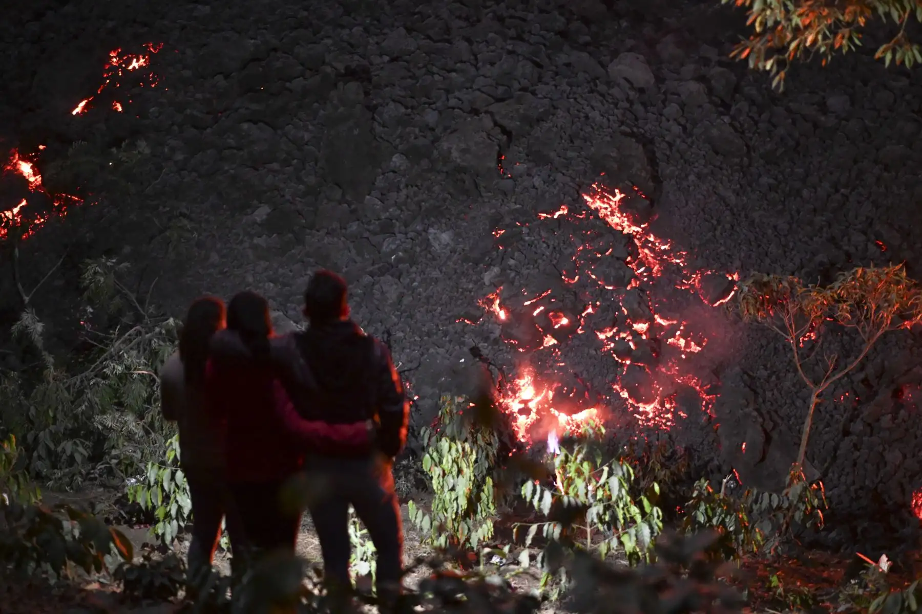 La gente observa cómo fluye lava del volcán Pacaya desde la finca La Breña, en el municipio San Vicente Pacaya, al sur de la ciudad de Guatemala. Foto: AFP