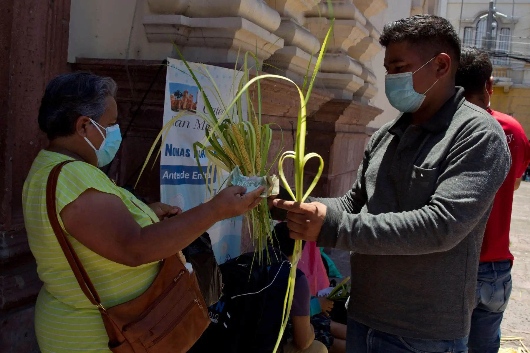 Una mujer compra ramos de palma a la entrada de la Catedral San Miguel Arcángel de Tegucigalpa . La pandemia de covid-19 que afecta a Honduras desde marzo de 2020 ha reducido este año las ventas de tiras palmas para su bendición el Domingo de Ramos en los templos católicos.
Foto: EFE