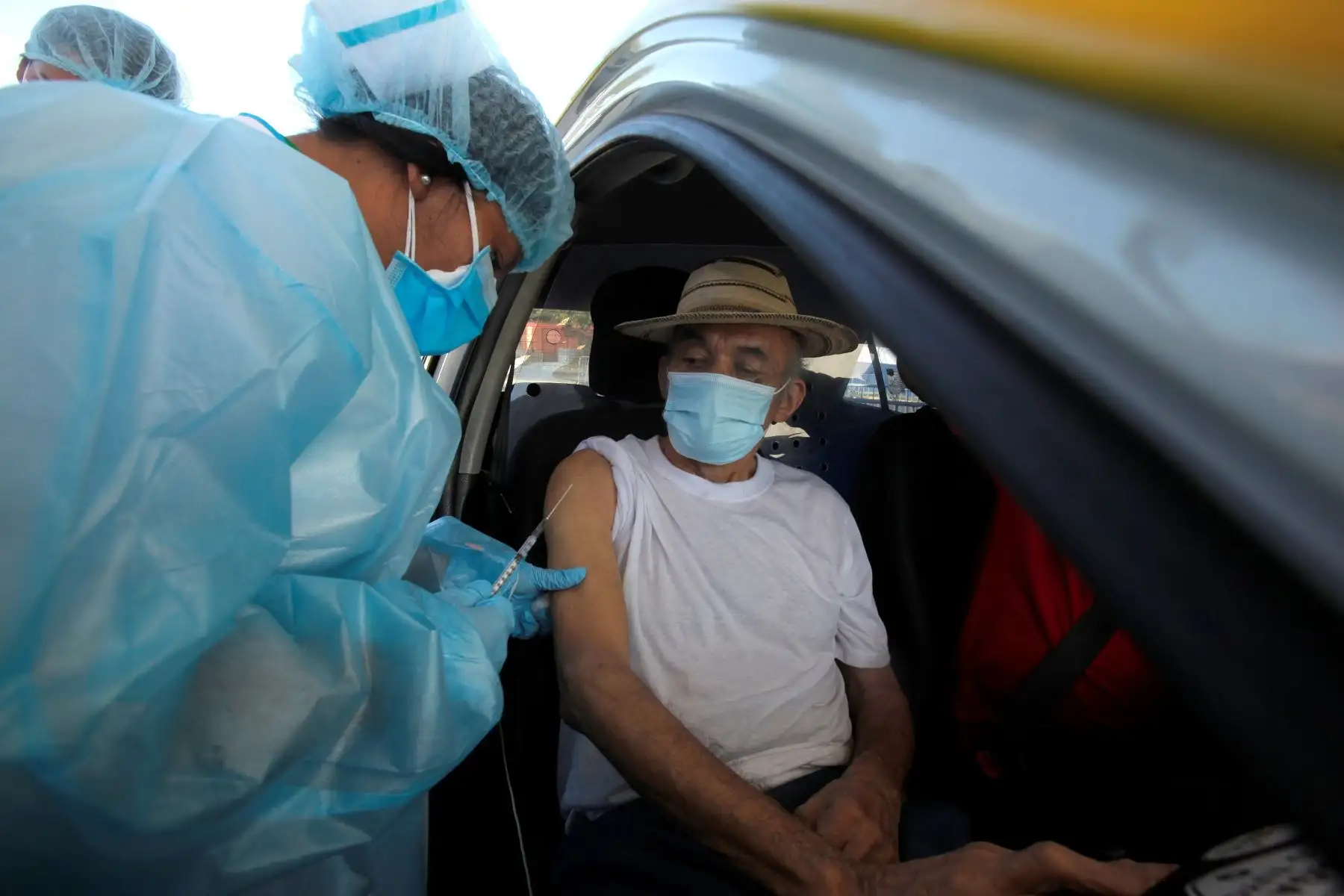 Enfermeras del ministerio de salud aplican la primera dosis de la vacuna Pfizer a adultos mayores de 60 años en sus automóviles en el centro de Vacunación Expres, en el corregimiento de Juan Diaz Ciudad de Panama. Foto: EFE